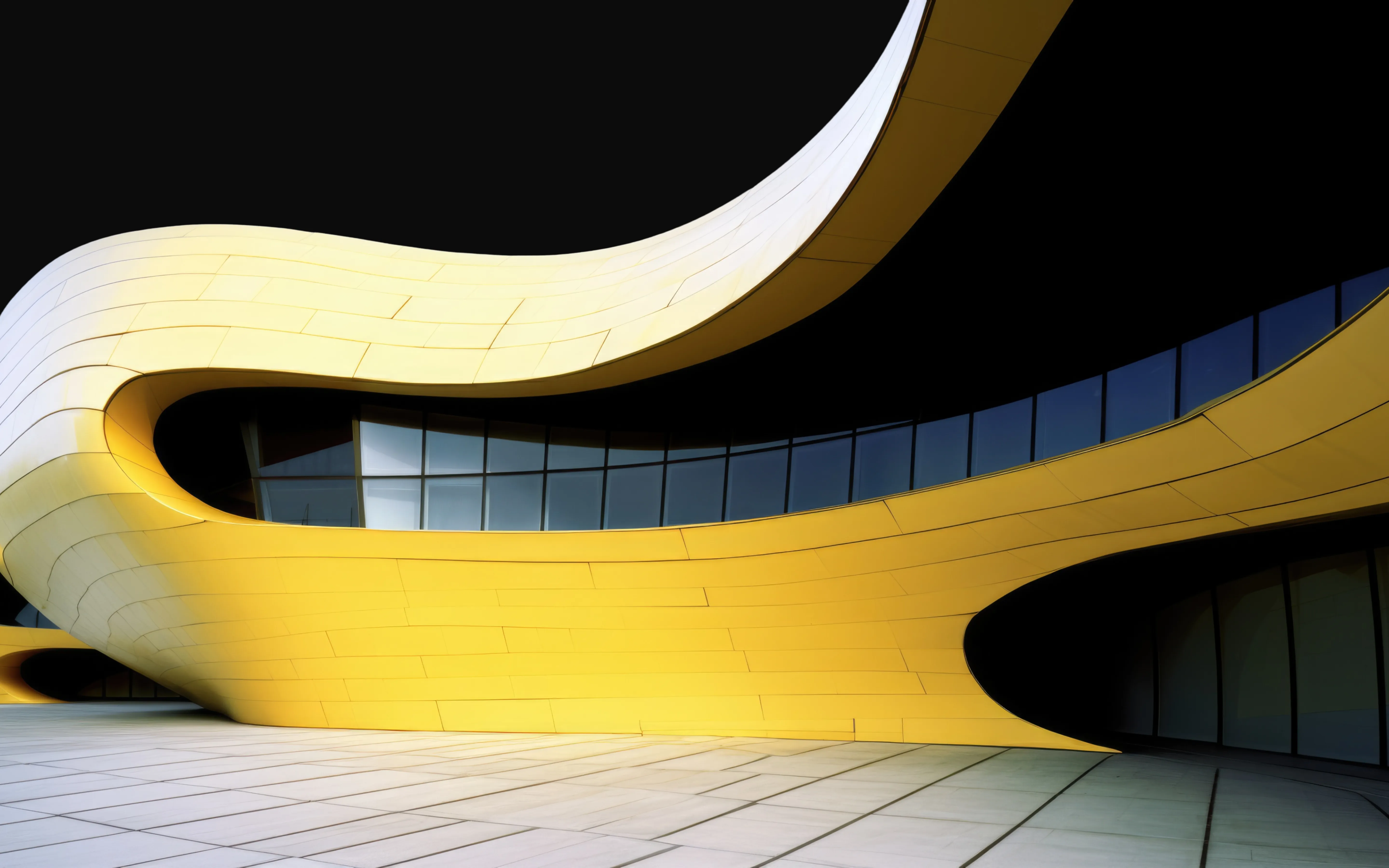 Curvilinear yellow futuristic building with flowing organic lines and dark glass windows against a black sky.