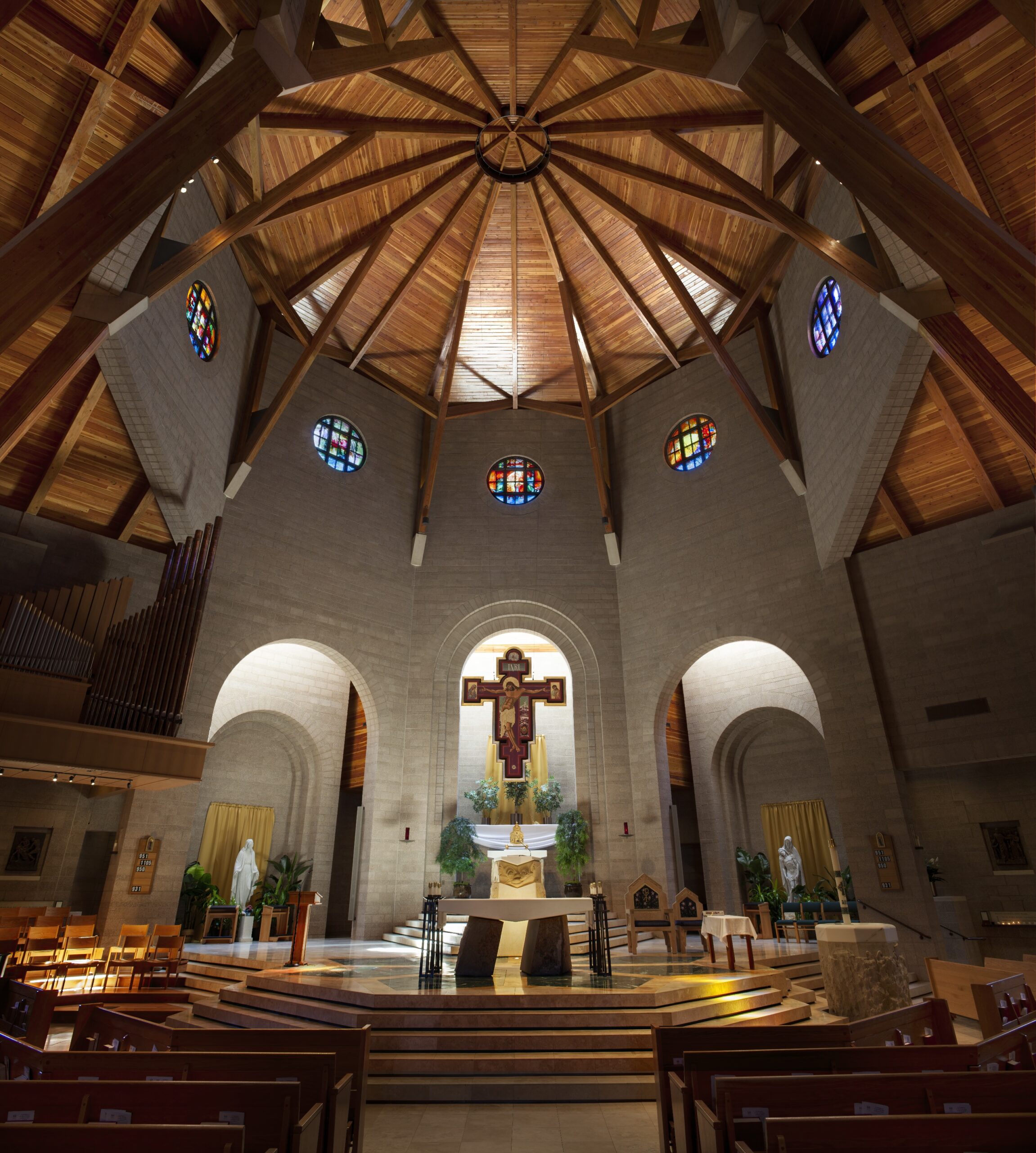 Church sanctuary with custom stained glass windows integrated into architecture, liturgical commission shaping light and worship experience