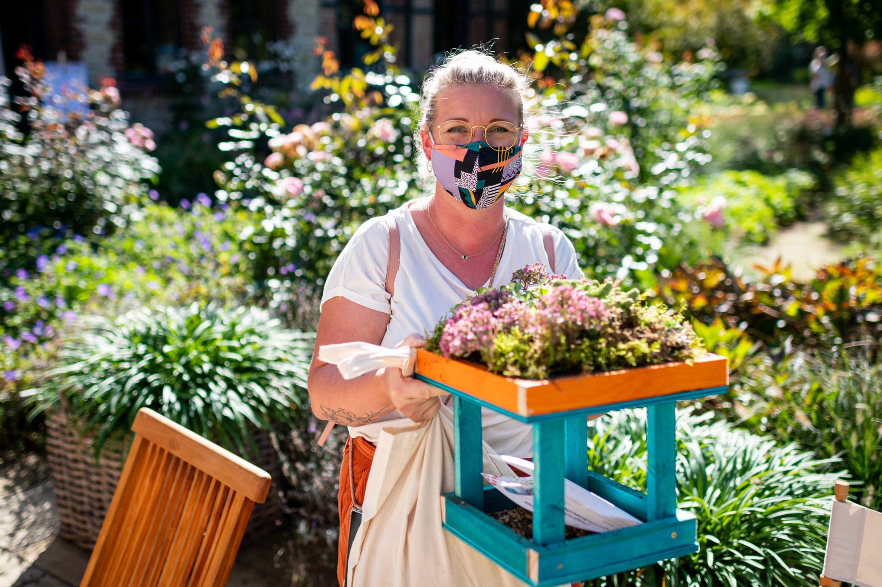 Eine Workshopteilnehmerin bei Gardena präsentiert ein bepflanztes Holzgefäß