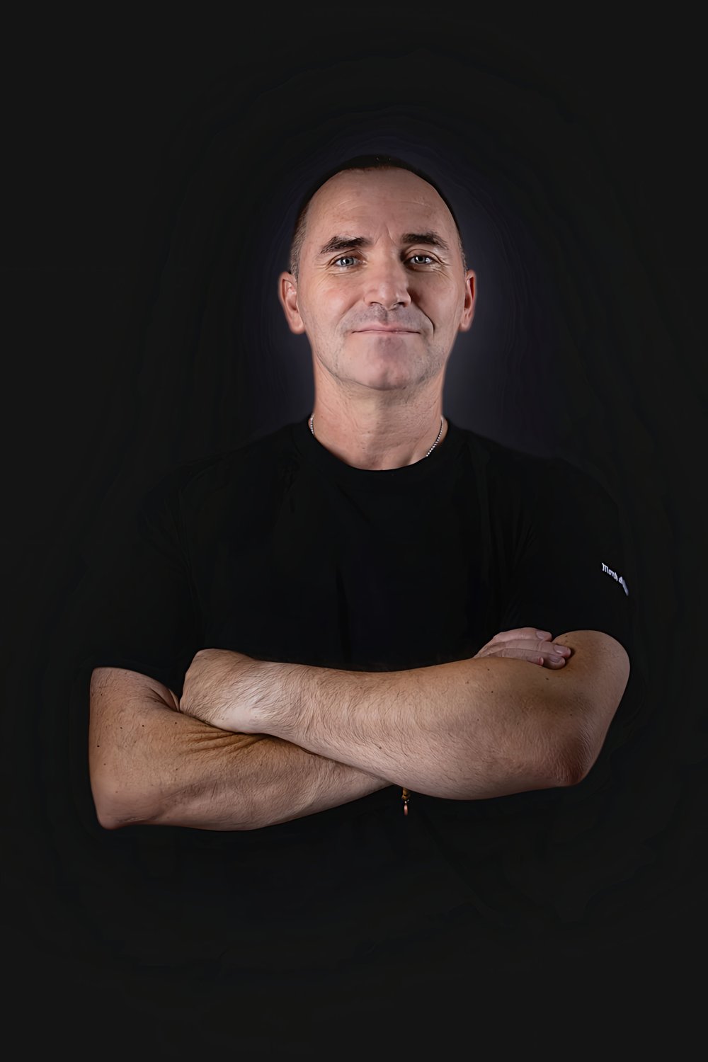 Homen de braços cruzados, em pose executiva