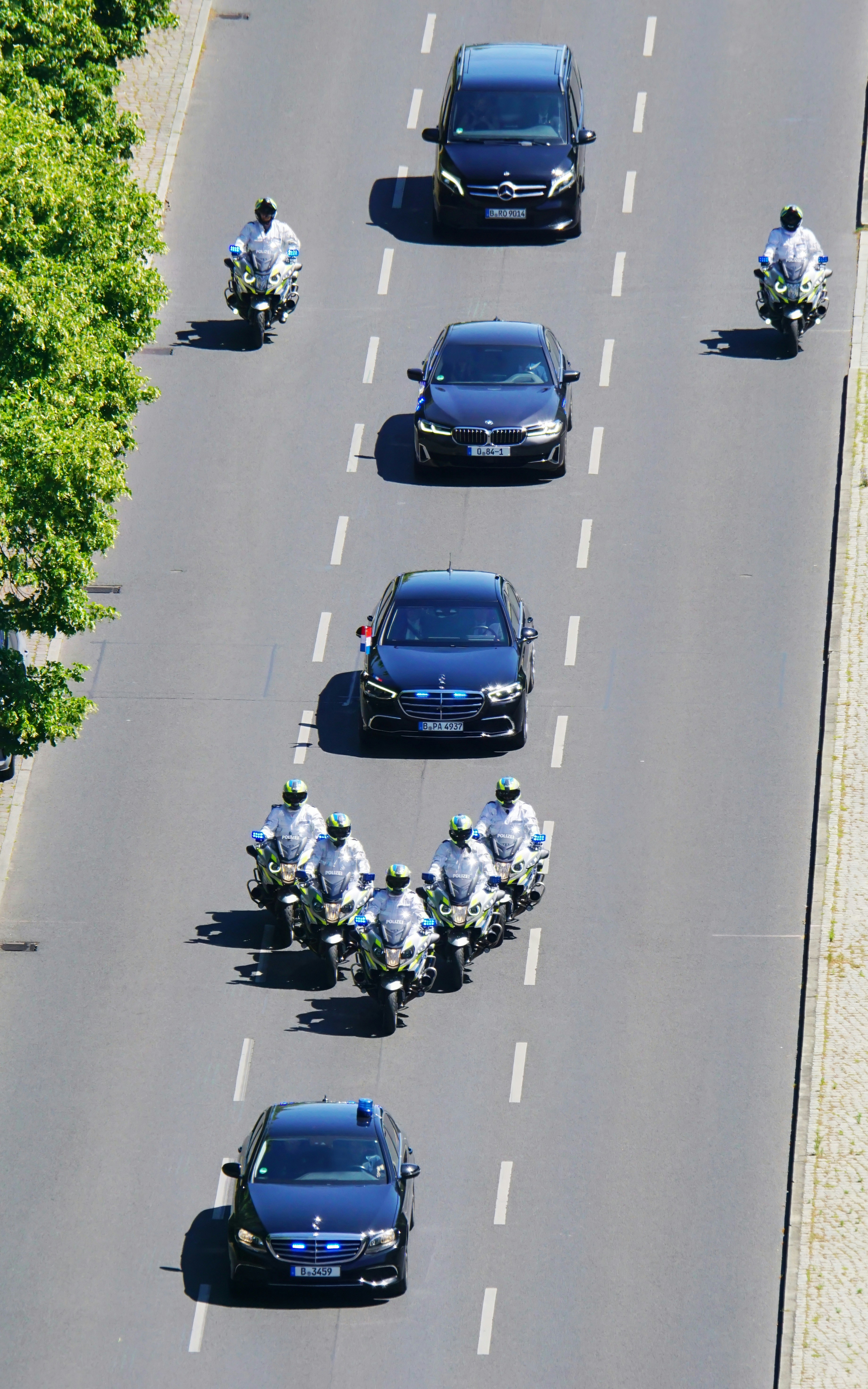 Motorcade with police escort on a city street.