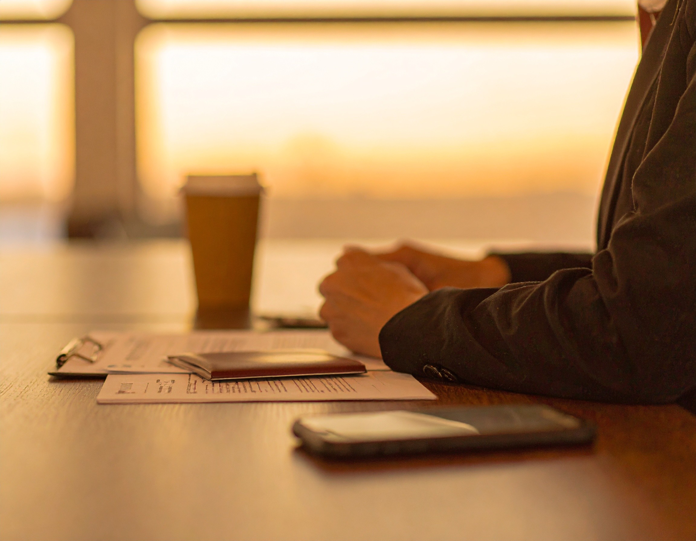 a close up of hands with various papers and desk materials