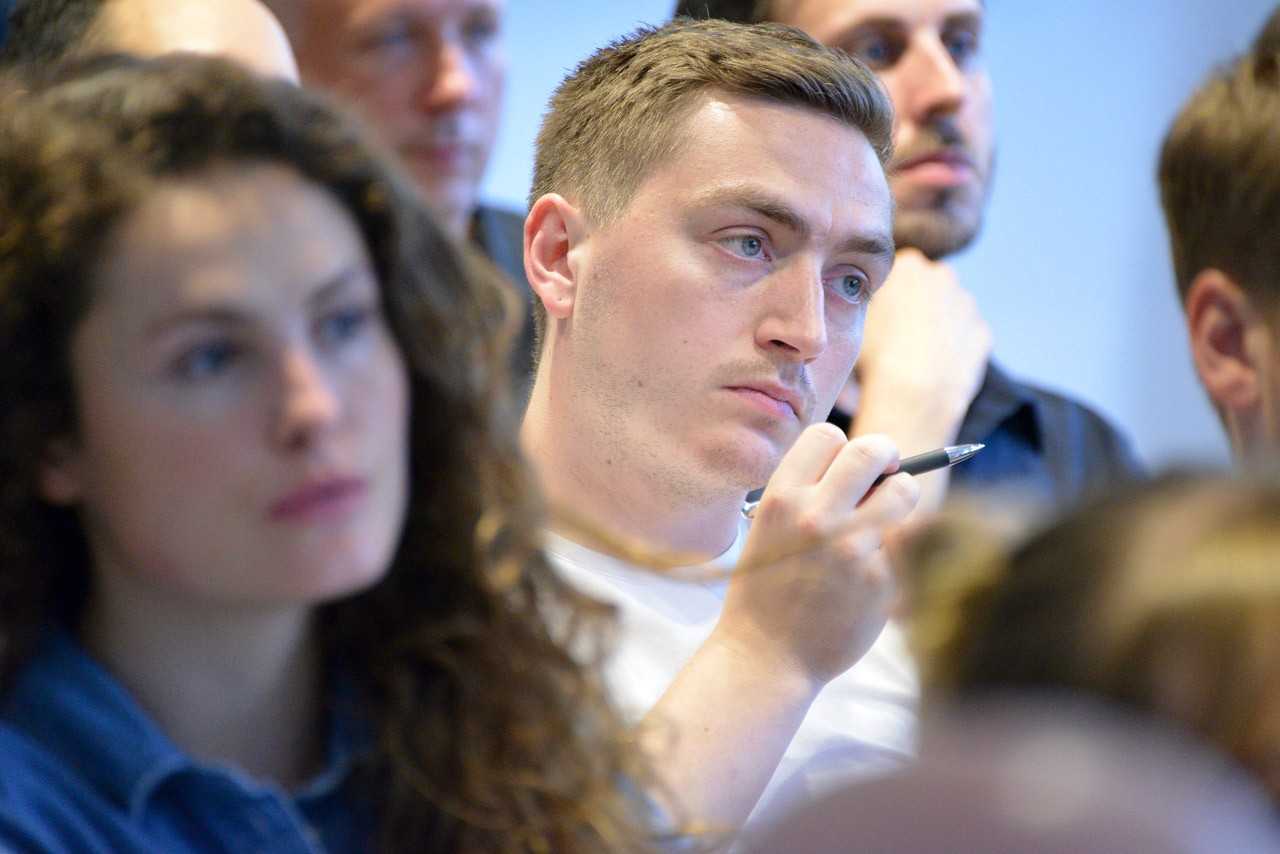 Mann mit Kugelschreiber - Nahaufnahme Publikum - Fachkonferenz Online Marketing - internetwarriors