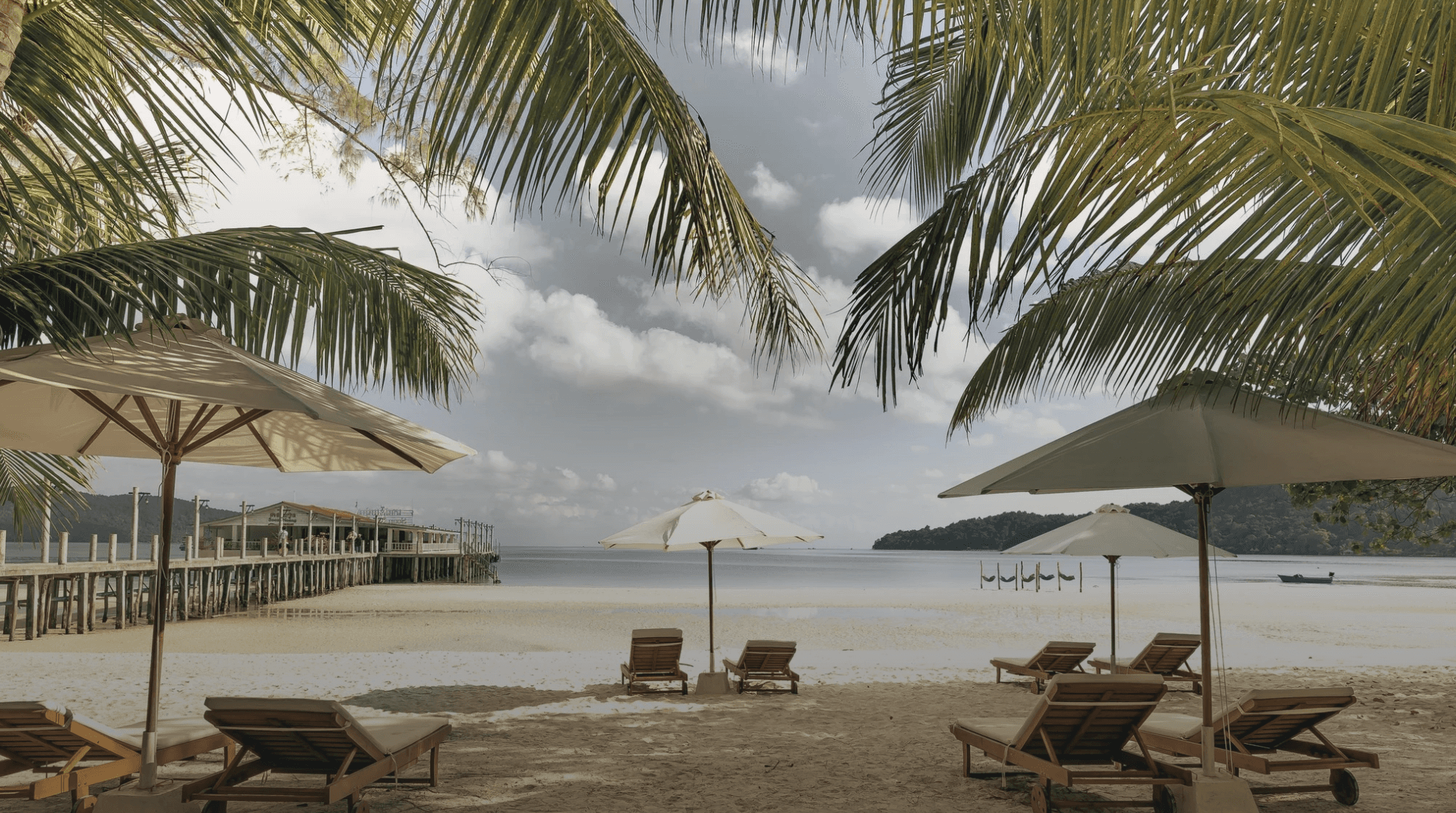 a person is walking on the beach at sunset