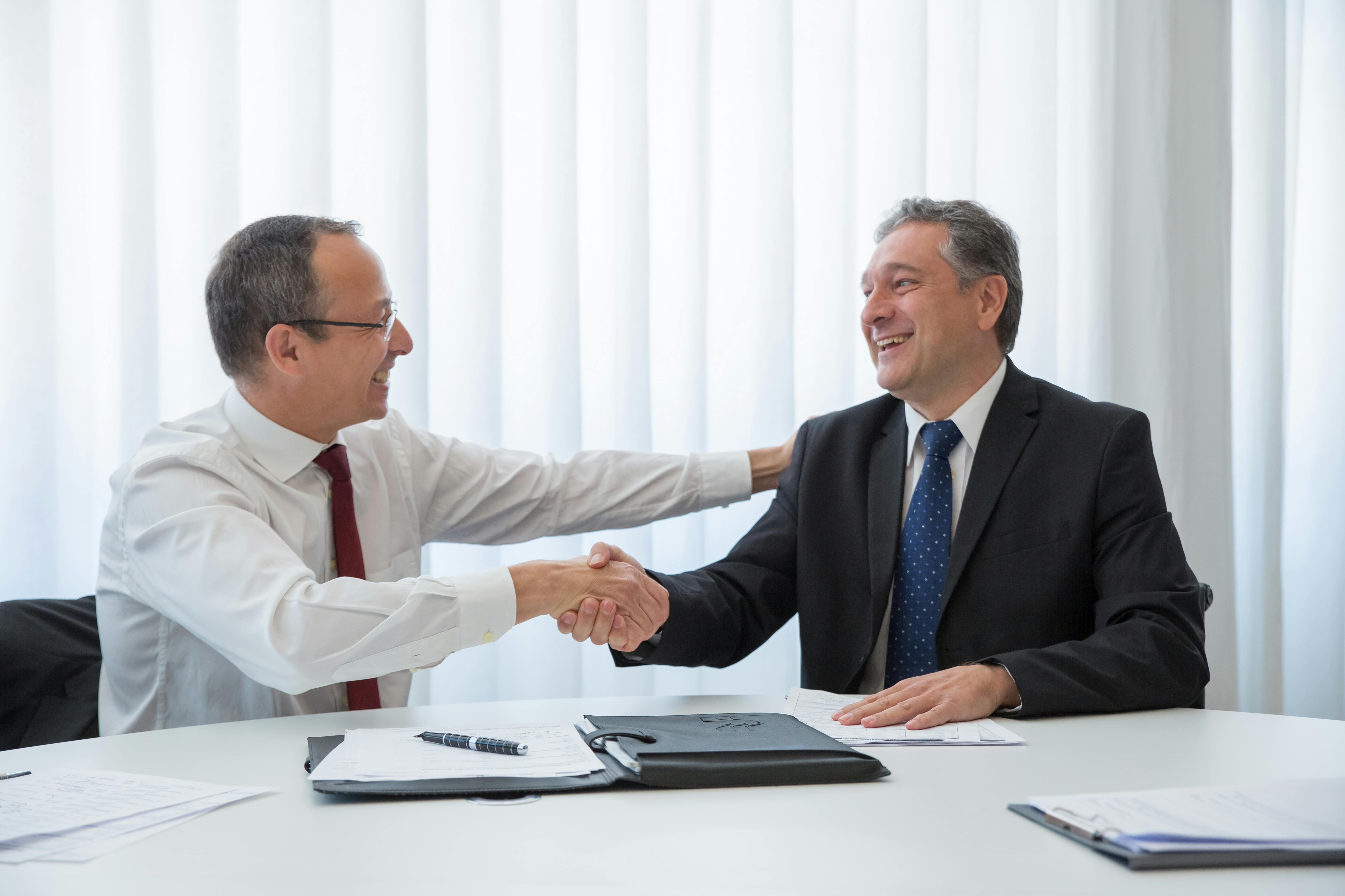 Broker and client looking at each other while doing handshake