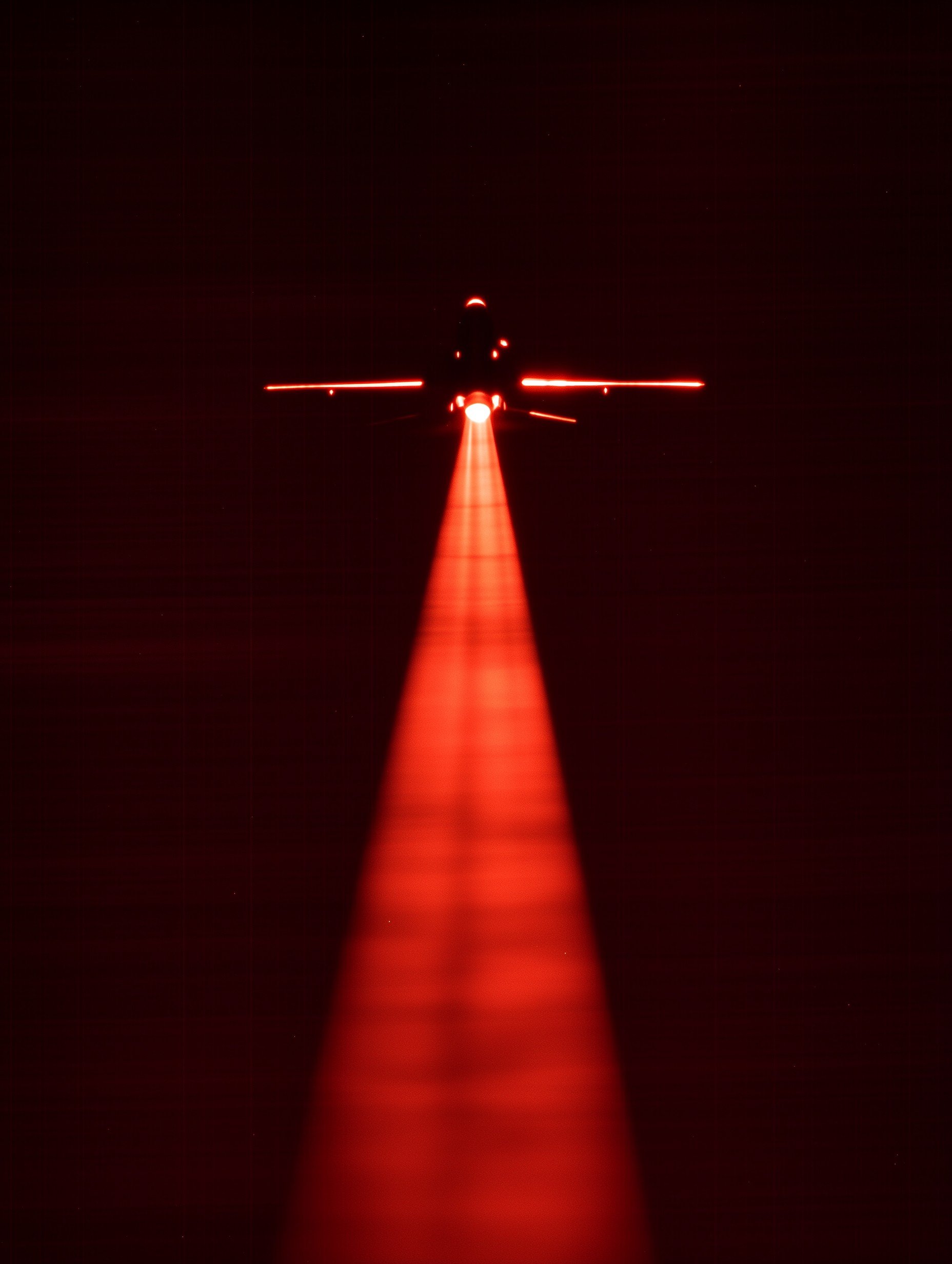Military jet silhouette with red light trail