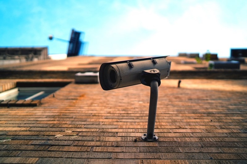 A CCTV security camera mounted on the wall of a brick building