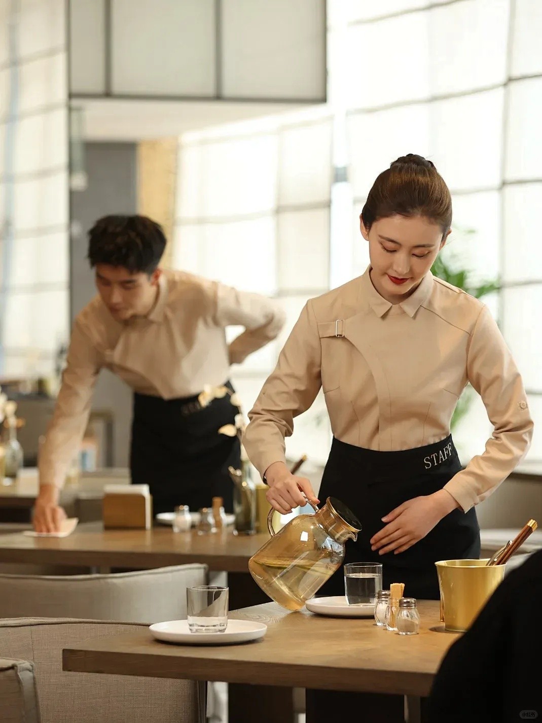 專業活動餐飲到會服務,身穿制服的侍應在優雅宴會場地準備飲品及整理桌面。
