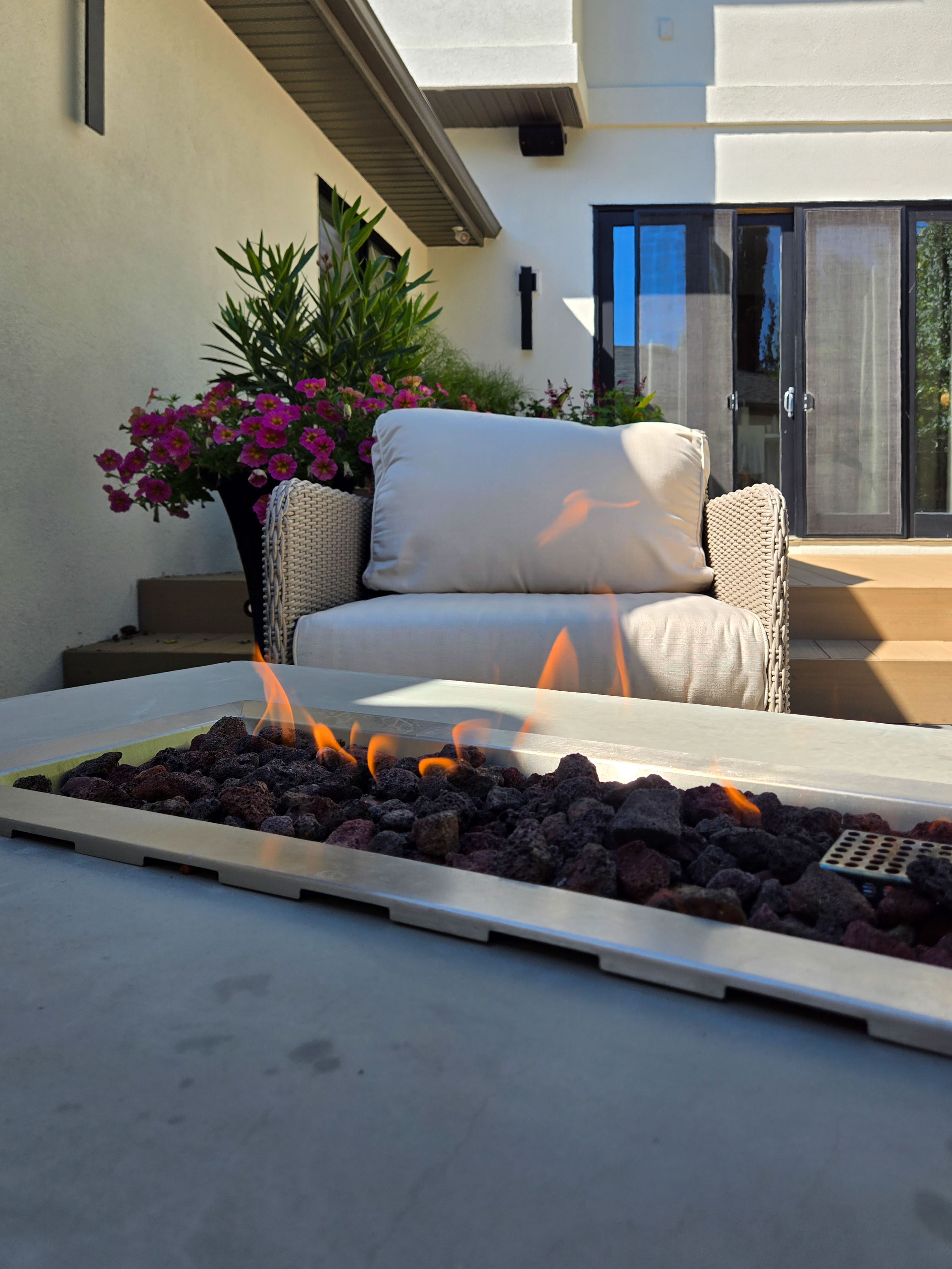 Image of KHD Homes outdoor living space with furniture, fire pit, and flowers for luxury home design and renovations.