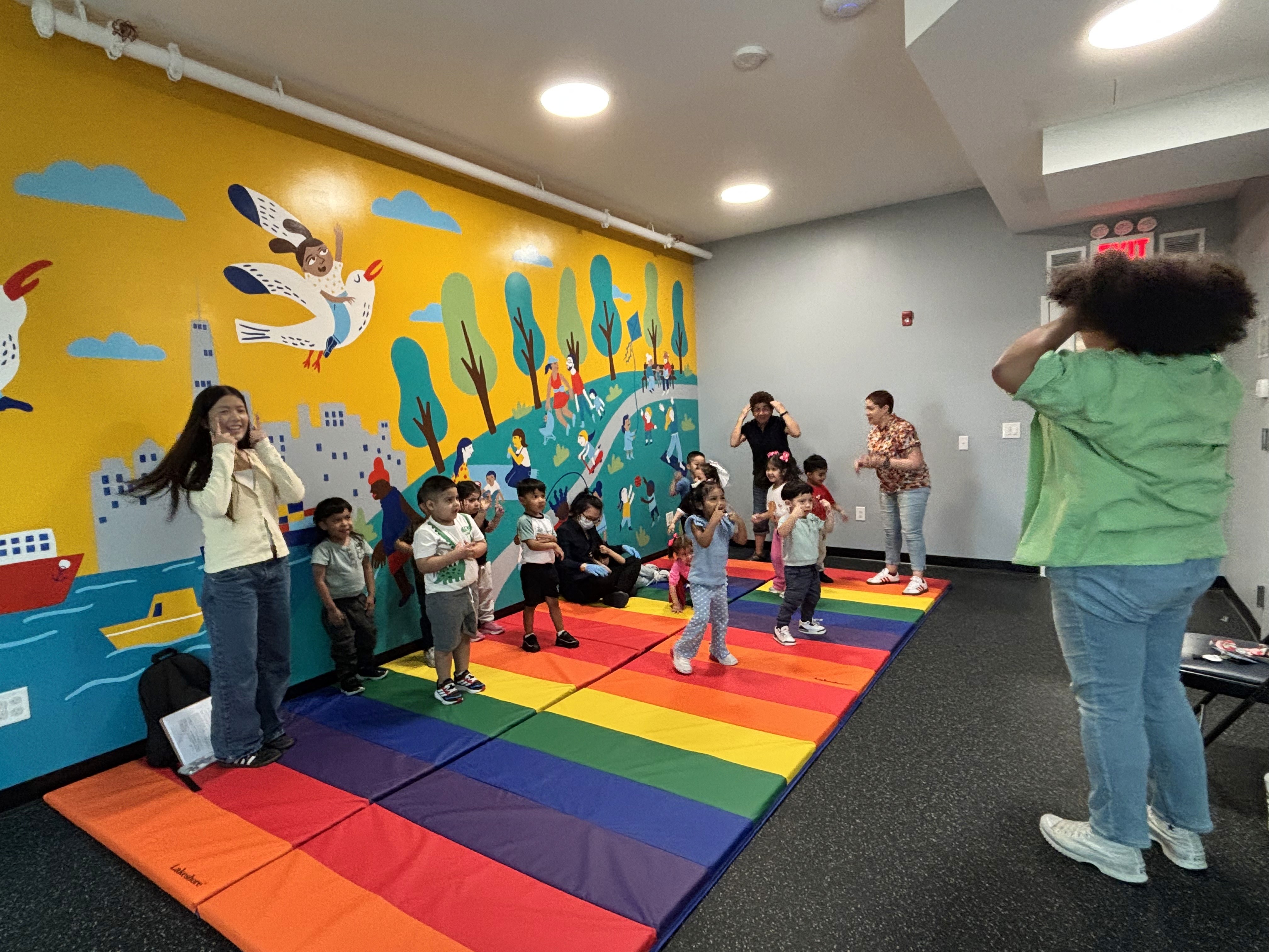 Preschoolers dance along to a teacher's instructions.