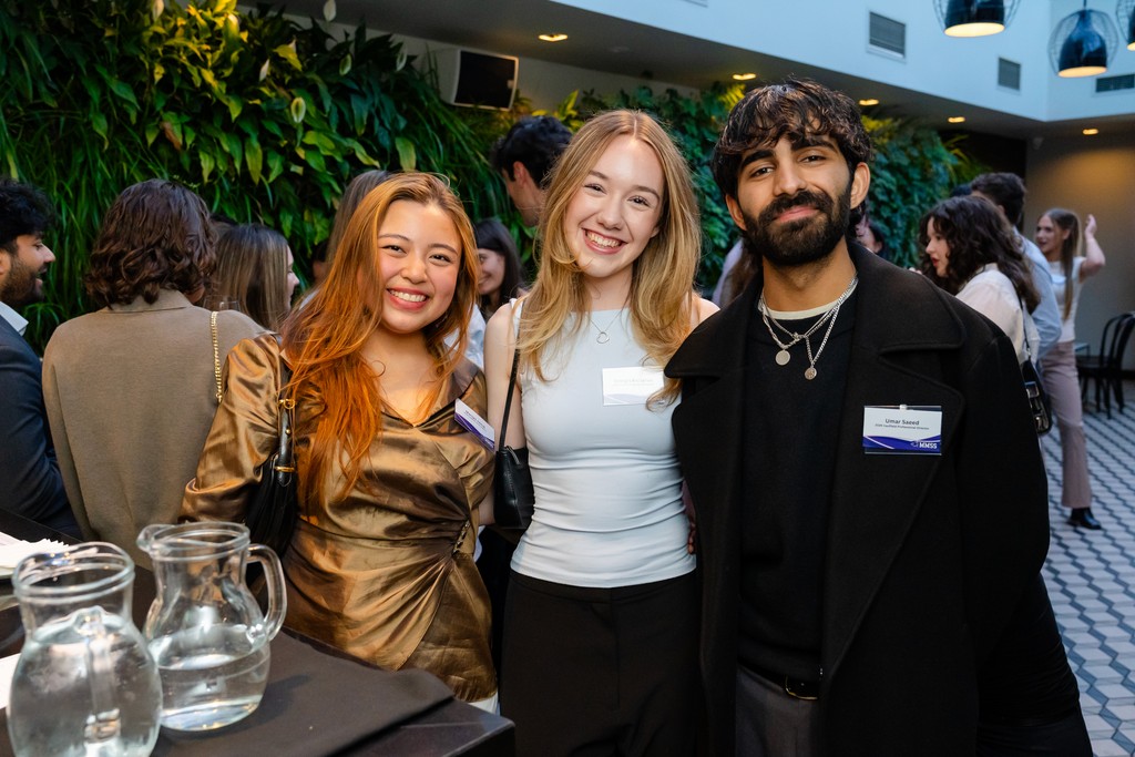 man in pink dress shirt wearing black sunglasses sitting on gray couch