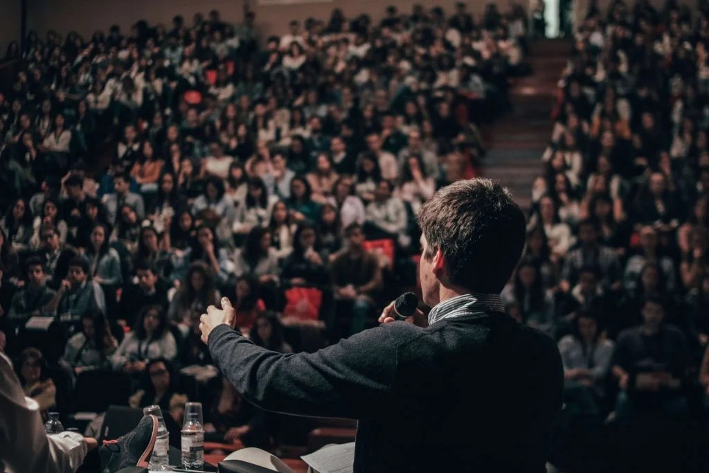 Man delivering a formal speech to a crowd