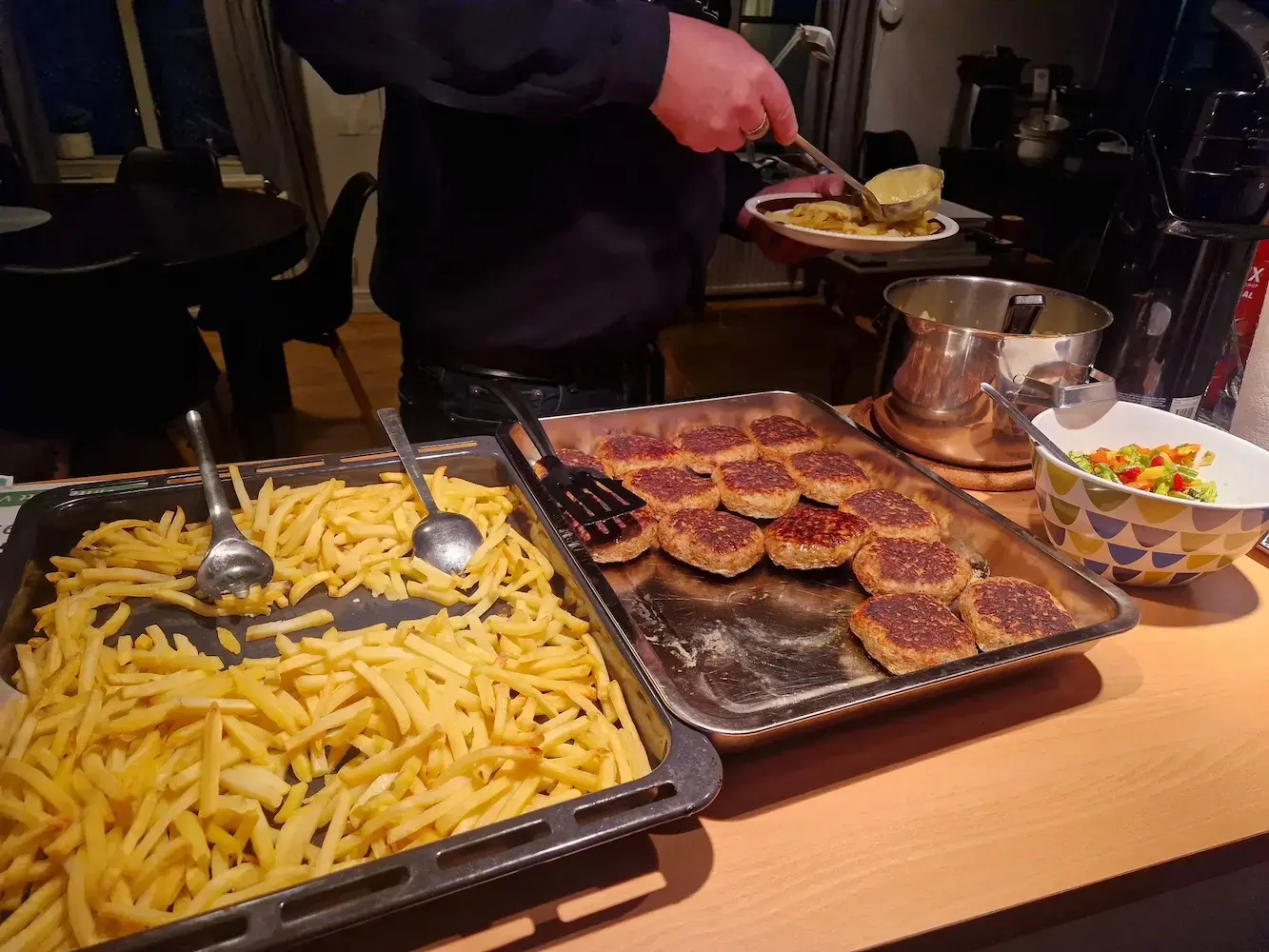 Mat serveras från uppläggningsbord med köttbullar och tillbehör.