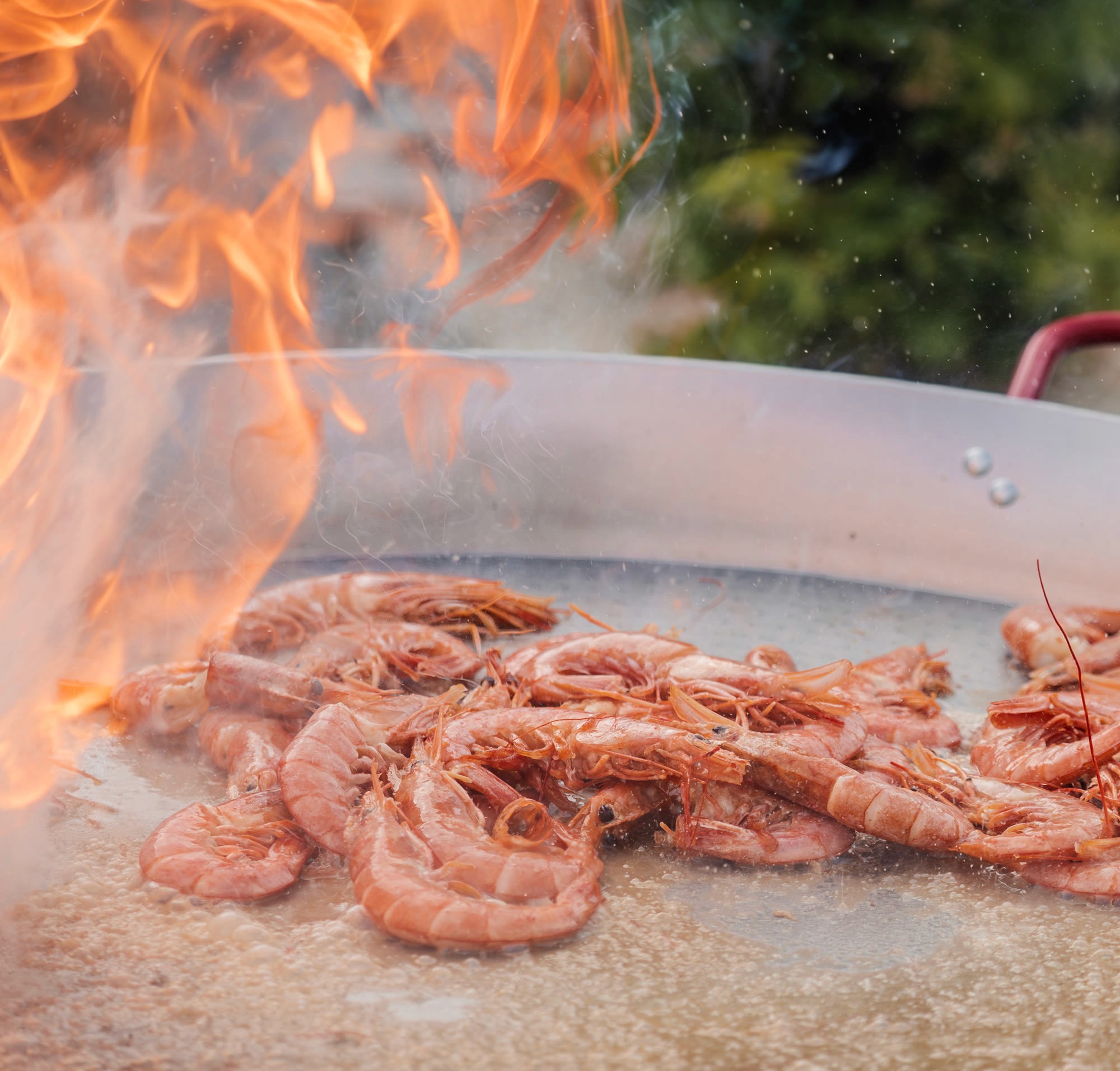 Gambas al fuego en la paella, durante un evento en la terraza del hotel