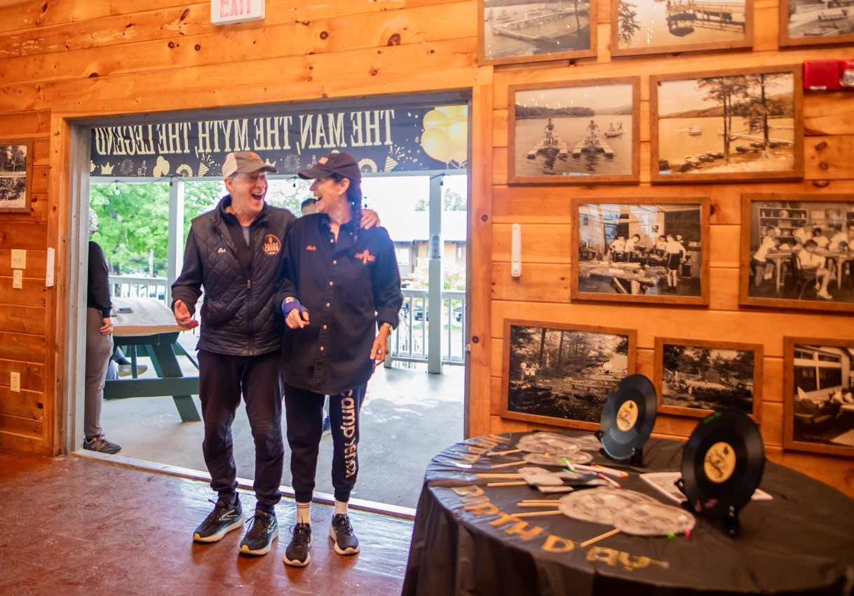 Rich and Stephanie Moss laughing together in the Camp Lenox lodge