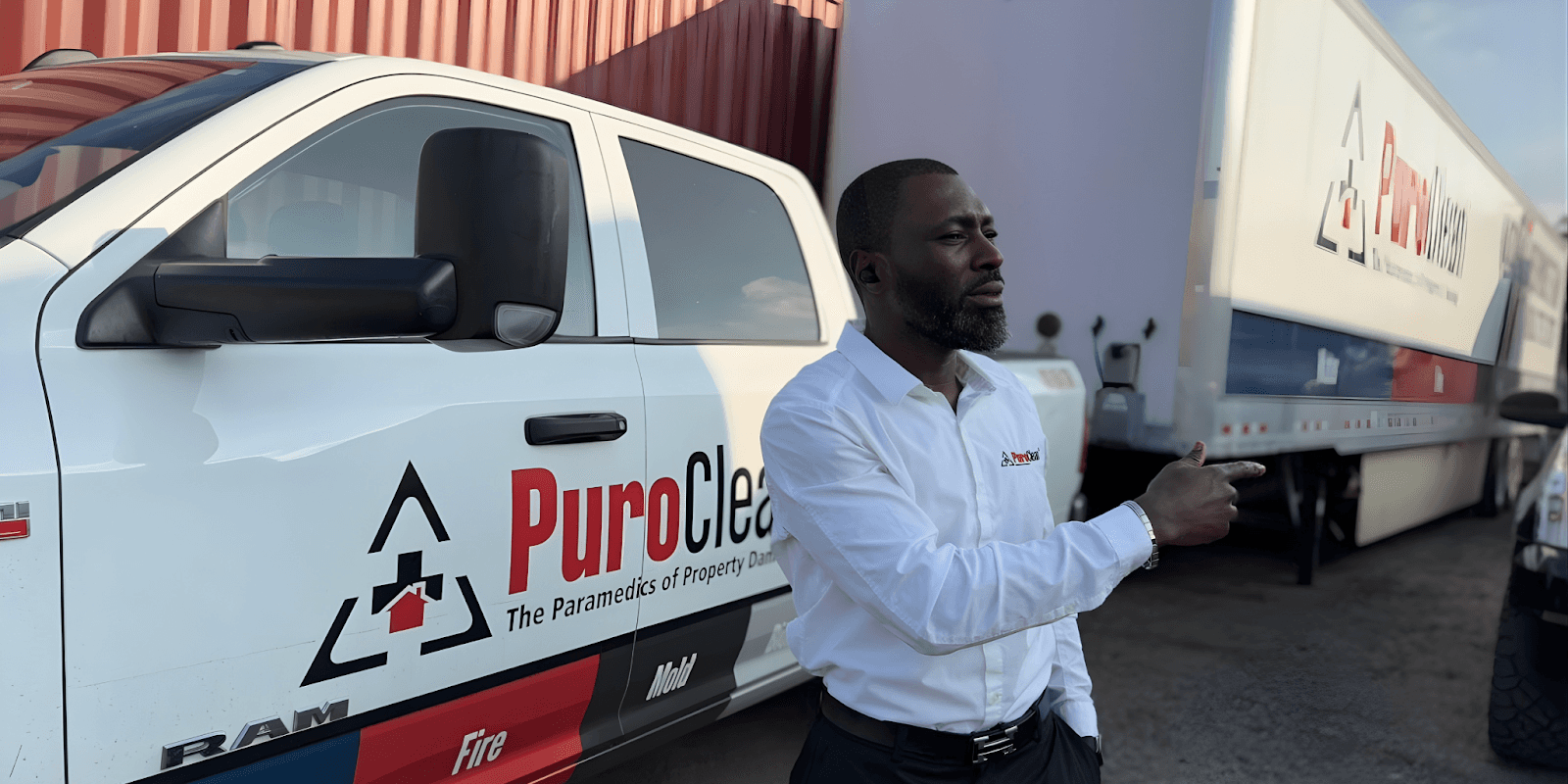 "Charles Omajuwa, entrepreneur and Puroclean franchise owner, showcasing leadership and resilience outside his business vehicle."