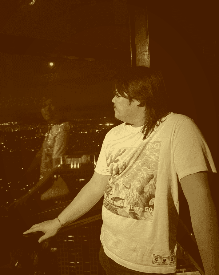 Photo of Evan Saisenesouk holding a Canon XSI Rebel camera in an outdoor garden in Madrid