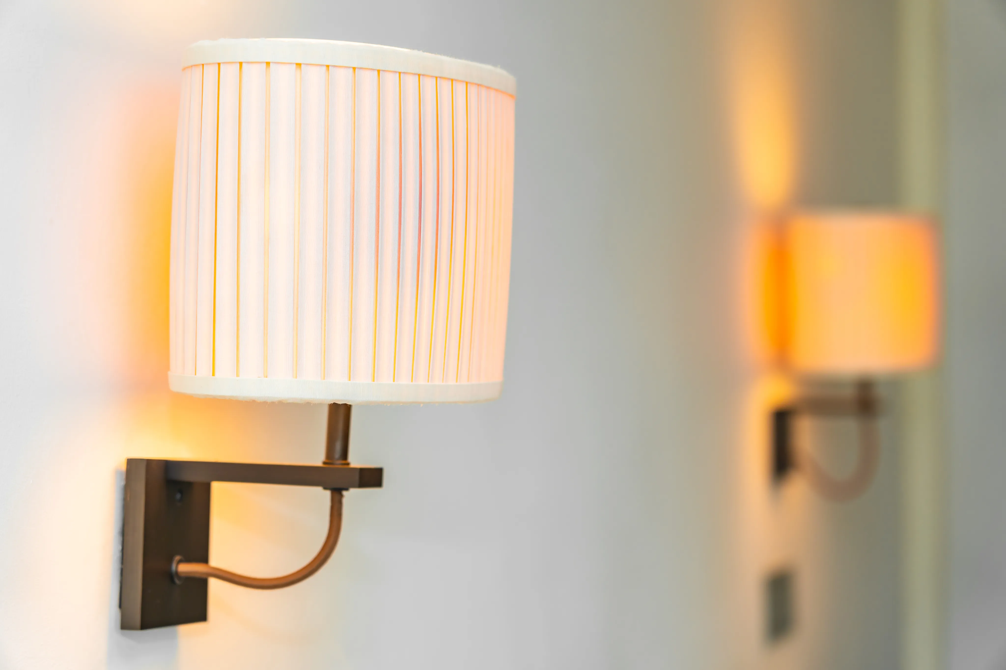 Pair of modern wall sconces illuminating a light wall with warm ambient light.