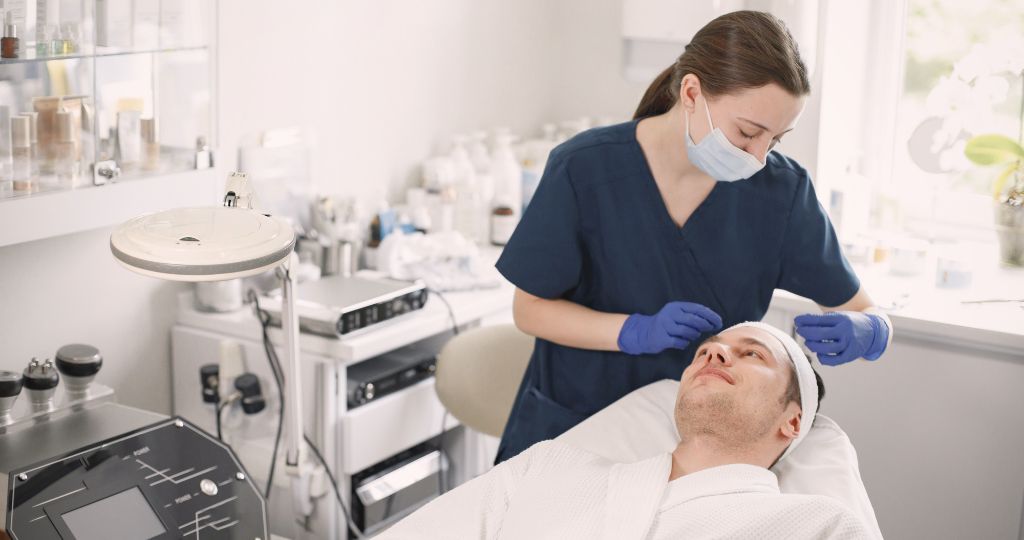 Dermatologist preparing male patient for a skin treatment in a clinic