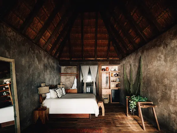 Oceanfront Room at Nômade Tulum highlighting spacious bed and harmonious architecture.