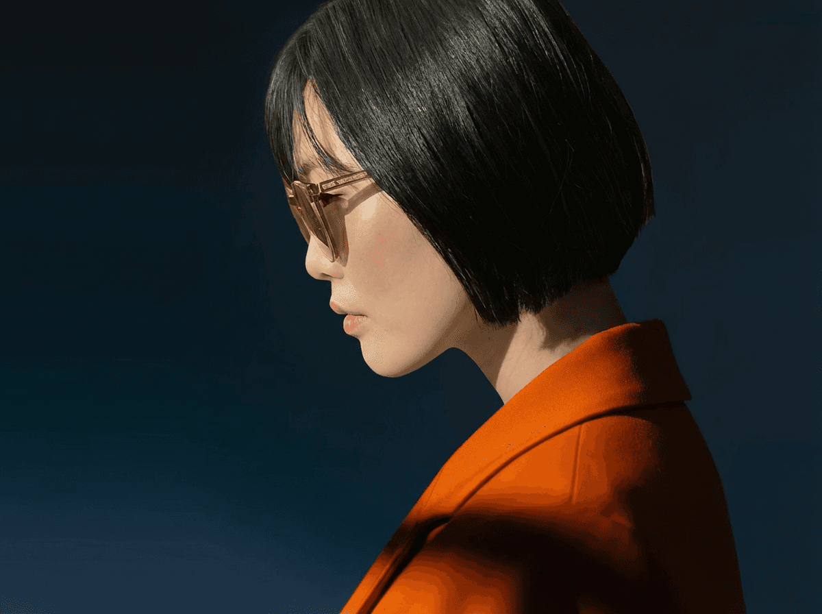 A thoughtful young person with dark hair gazes to the side, captured in soft black and white lighting.