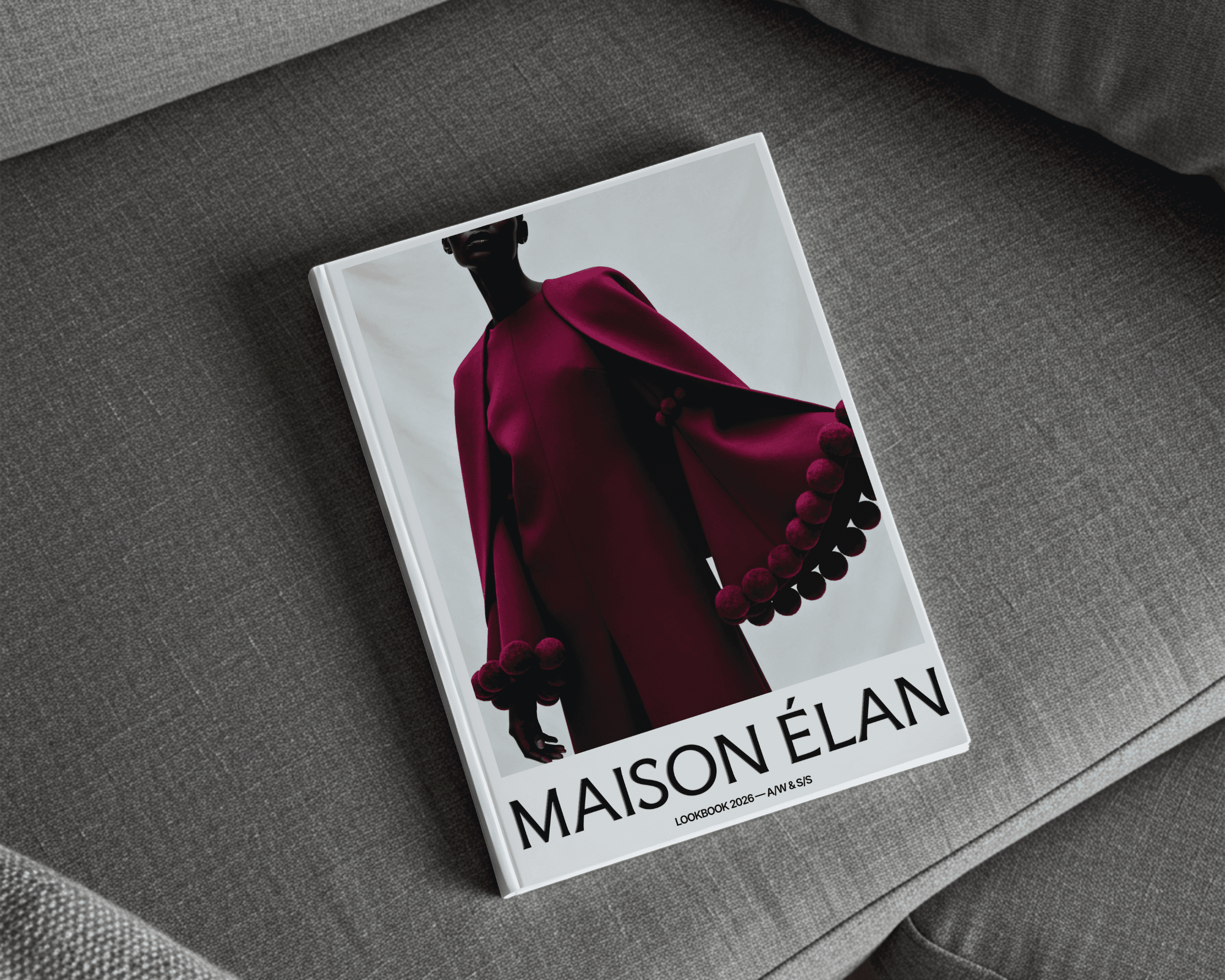 A book cover for a Maison Élan lookbook featuring an image of a woman wearing a burgandy outfit with the brand logo printed on the bottom.