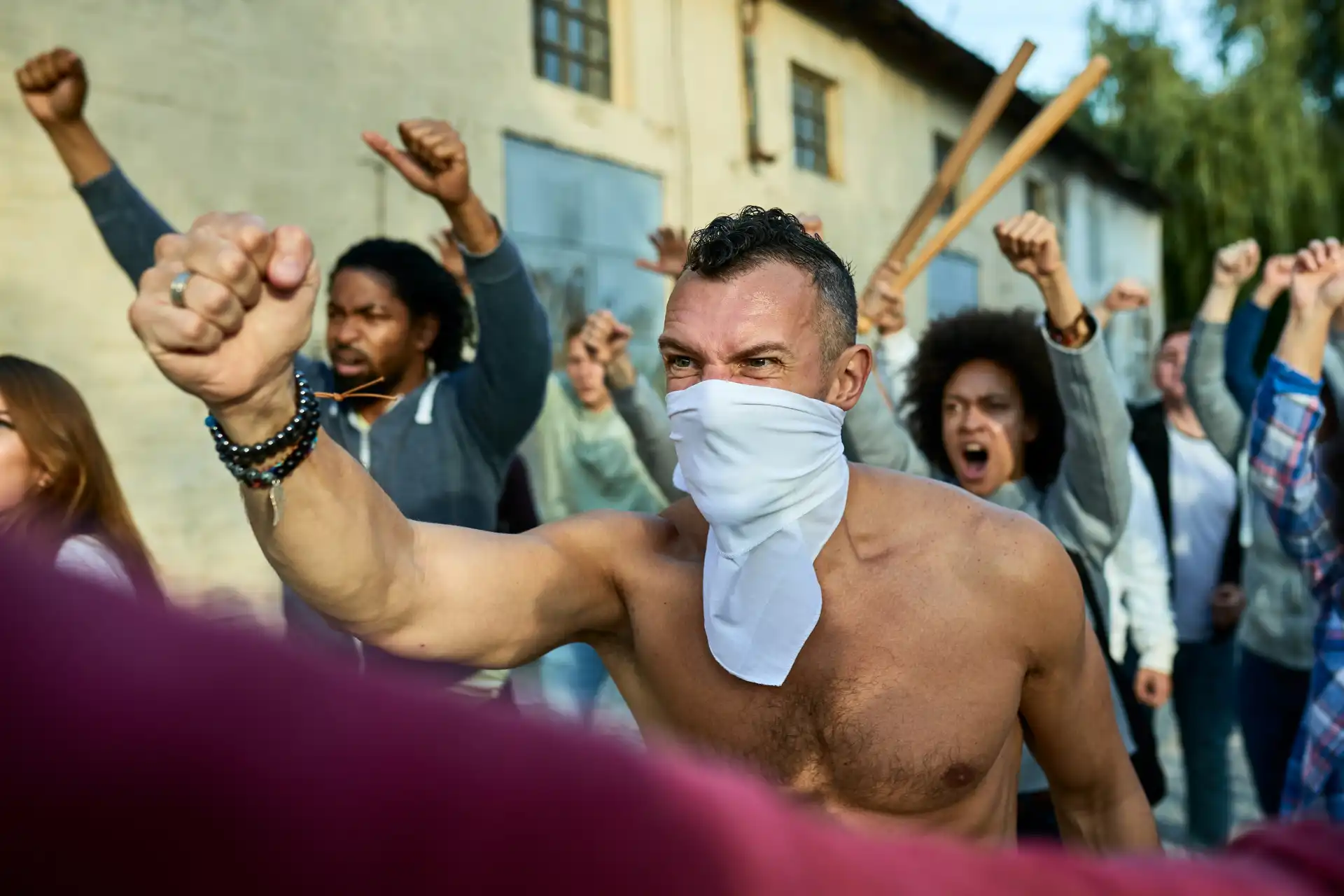 A masked rioter raising a fist, symbolizing the violent extremism and hate groups TikTok’s AI systems actively target.