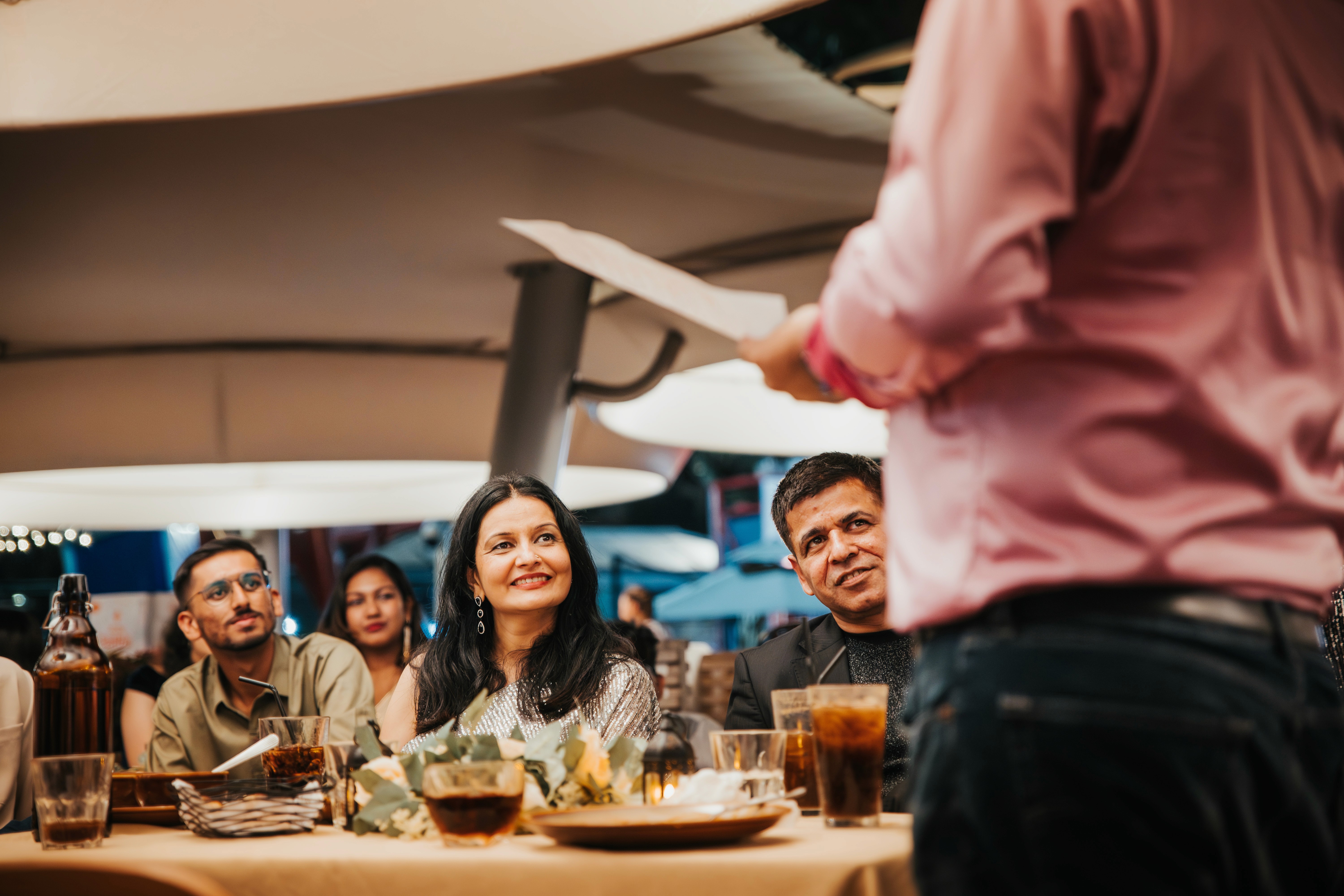 The married couple reacting with joy to anecdotes during a family speech.