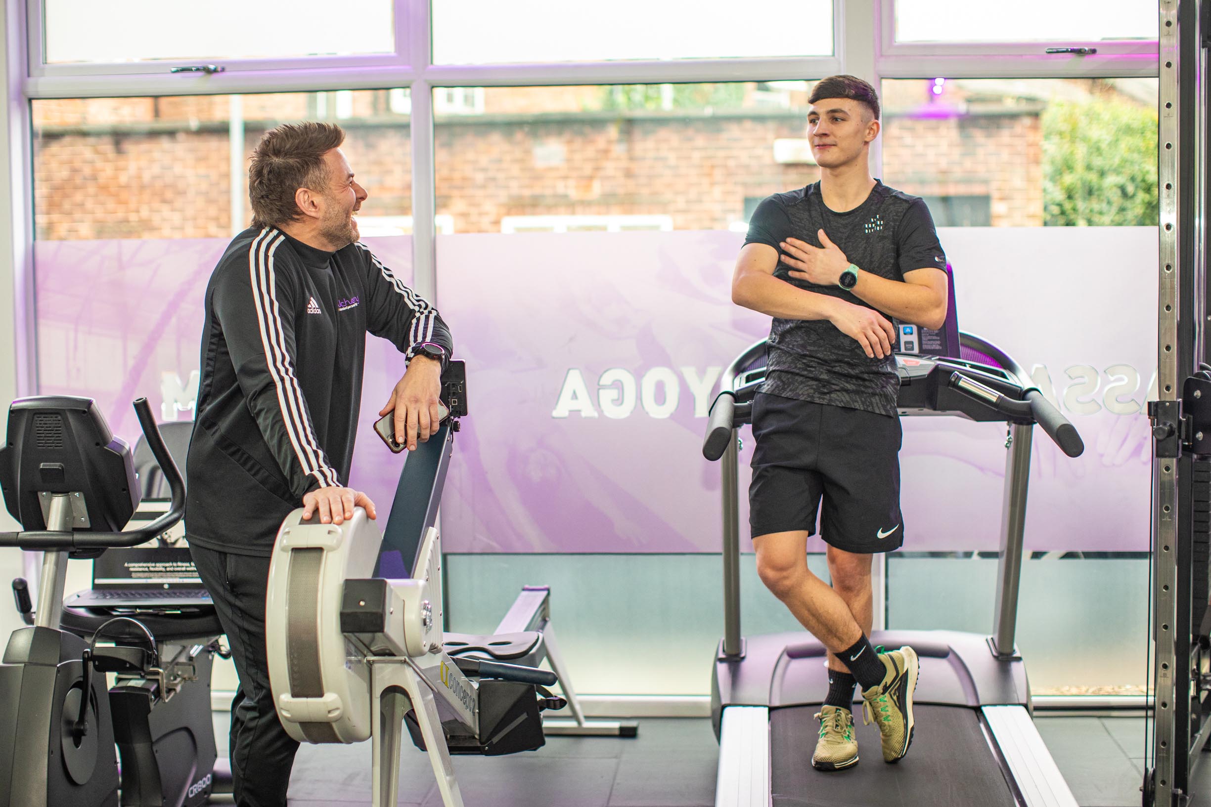 Two Alchemy fitness trainers discussing what is pre work out and how it can improve one’s health