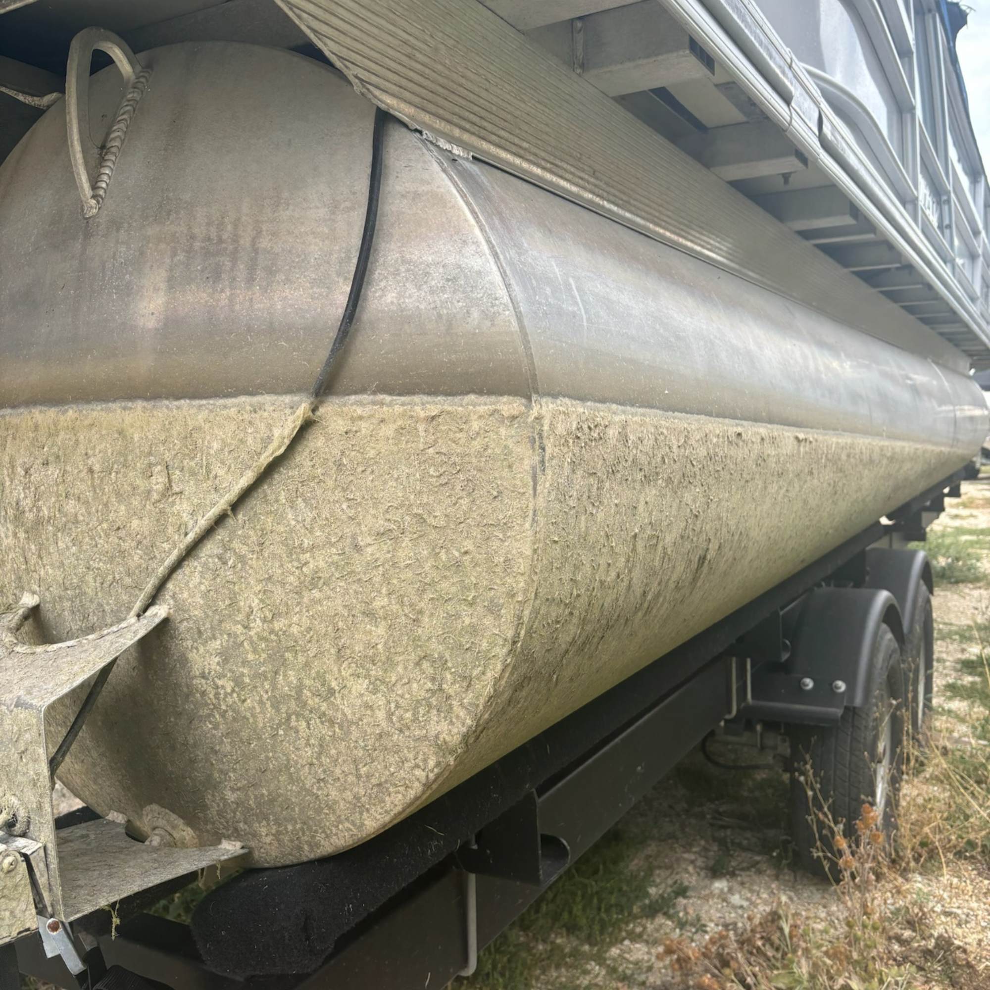 Close up of a pontoon that needs to be acid washed. Heavy oxidation and organics after a long season in the water. Needs a deep clean