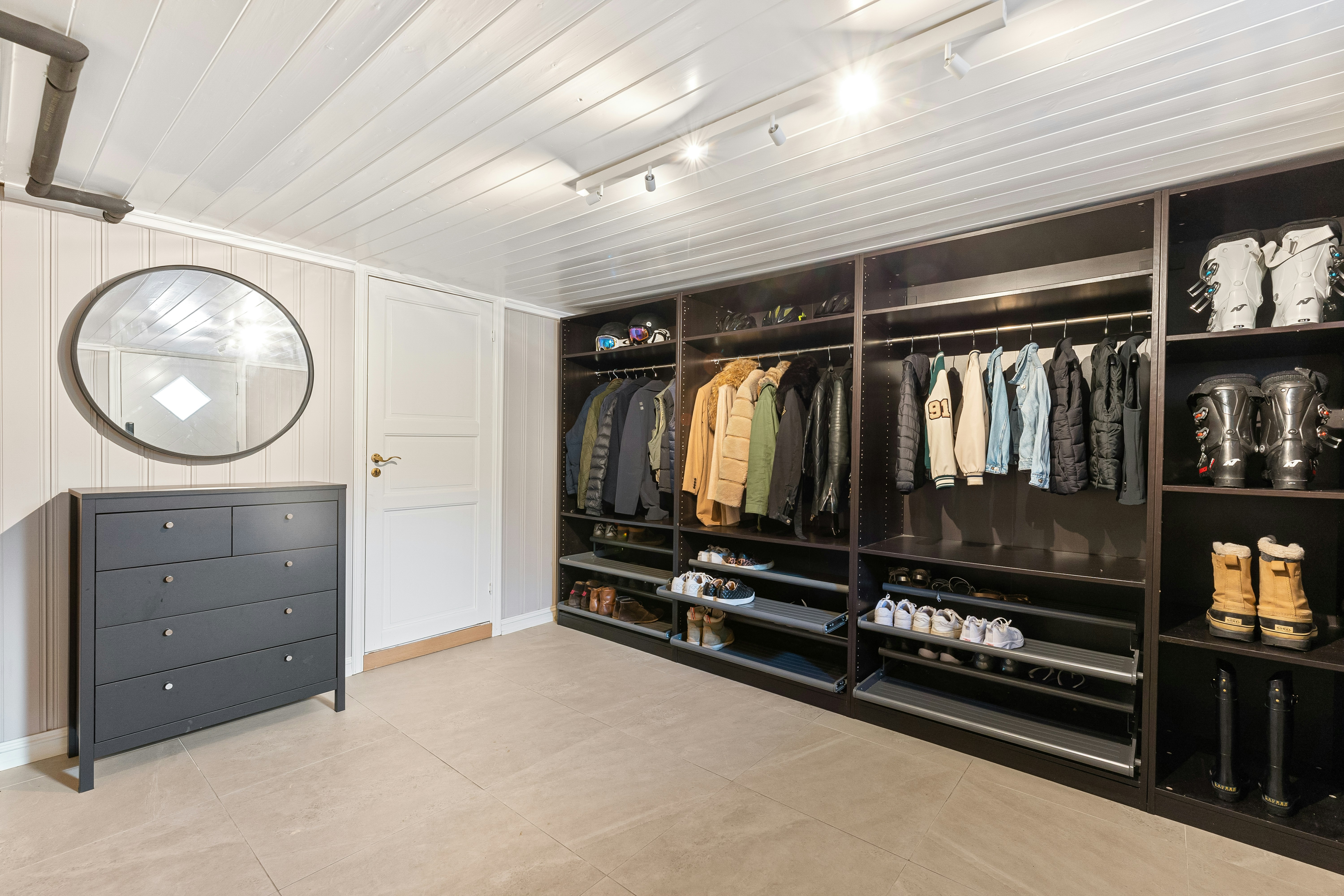 A walk in closet with a mirror and a clock