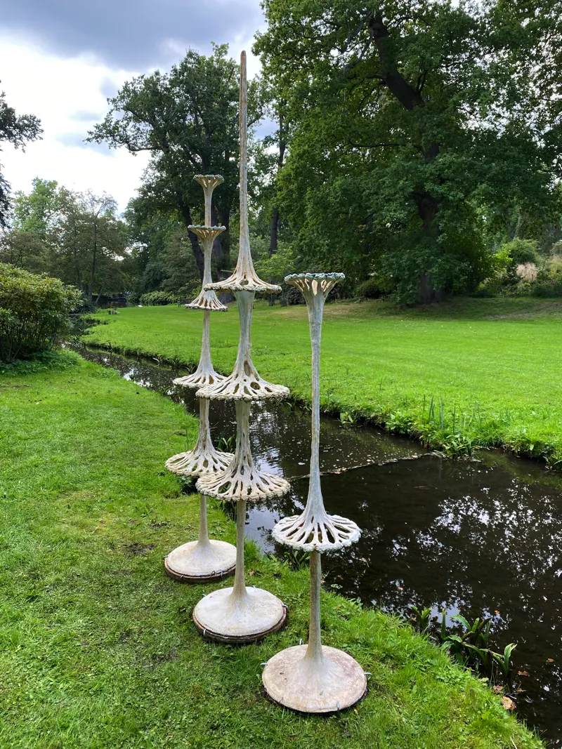 tri of lichenscope sculptures next to stream