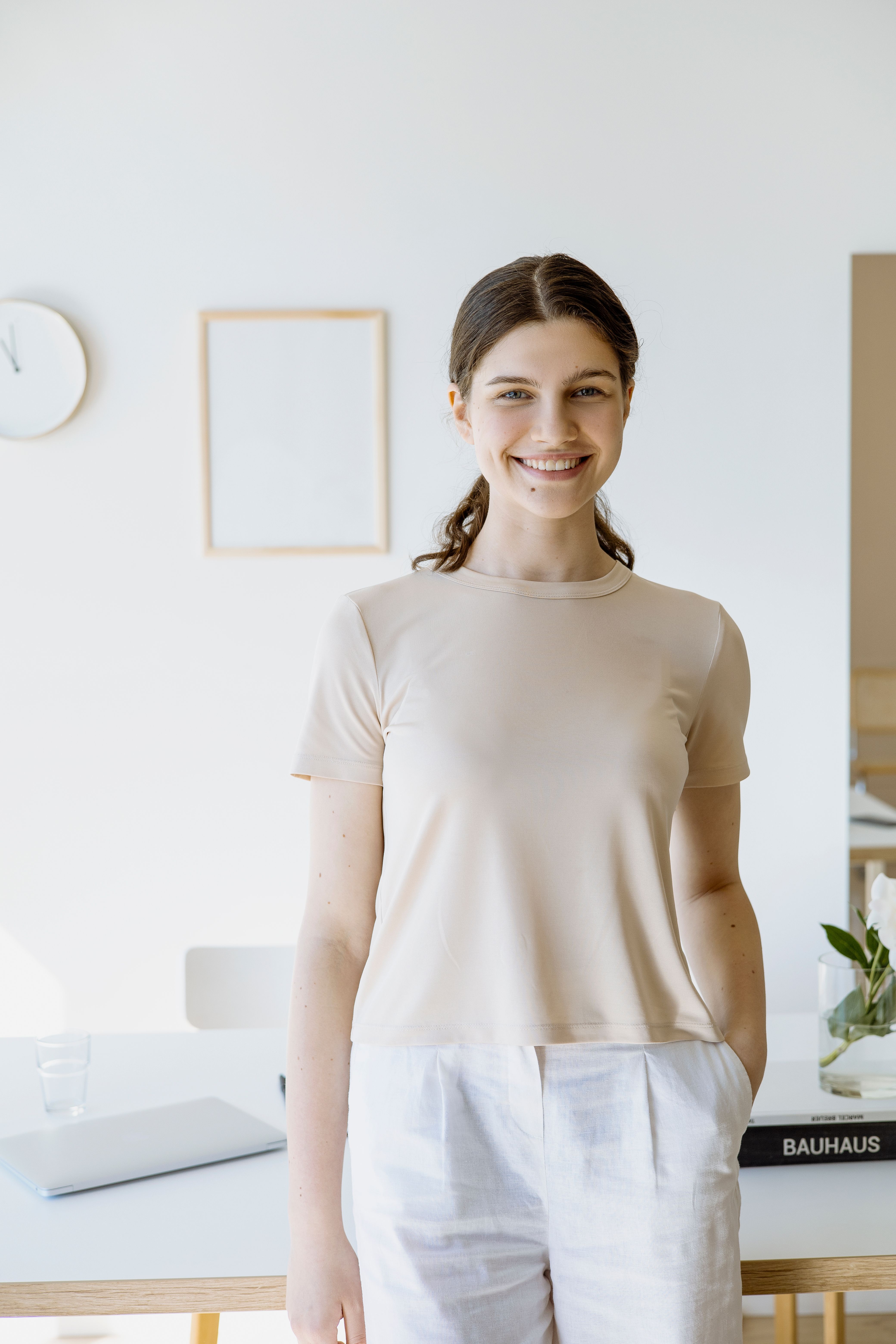 a woman sitting on a white chair next to a table