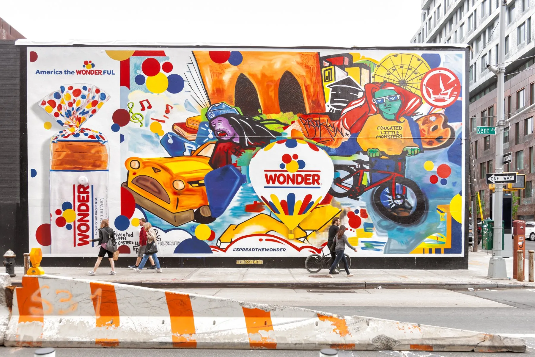a man walking down a street past a large poster