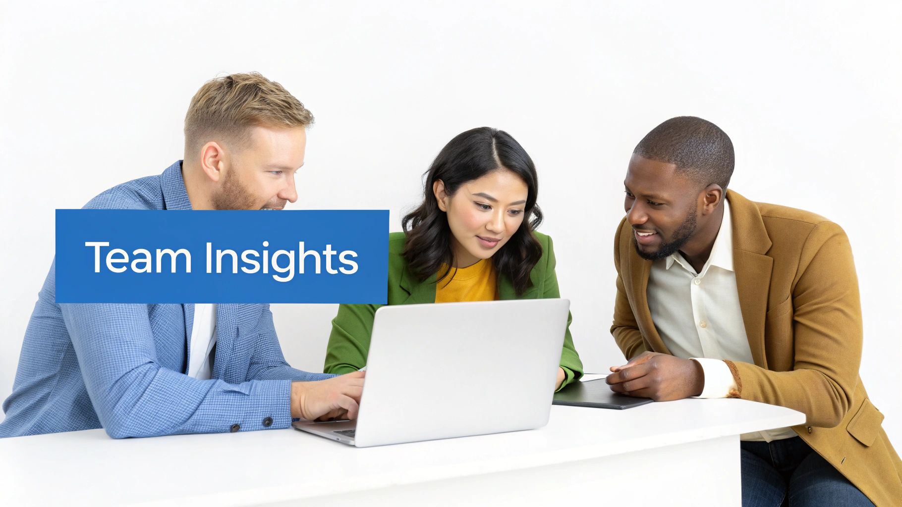 Three diverse professionals collaborate around a laptop, discussing team insights on a white table.