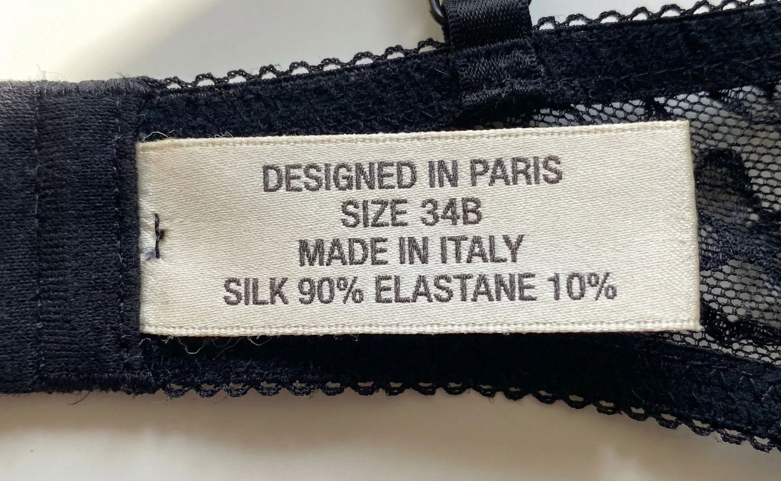 Close-up of a lingerie label reading Designed in Paris and Made in Italy.