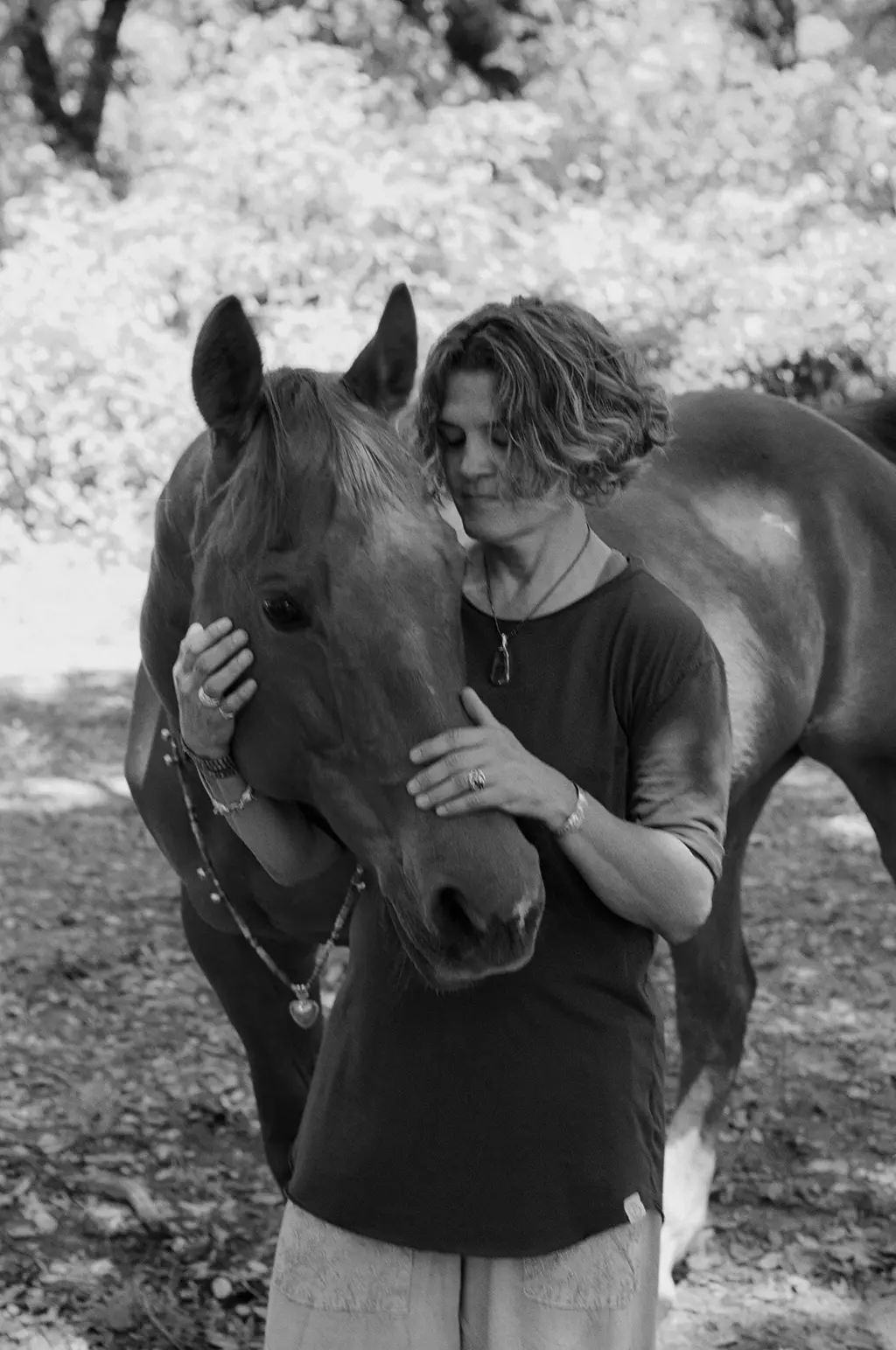 Sonia Marie Salas, somatic and entheogenic healing practitioner, embracing her horse Corona