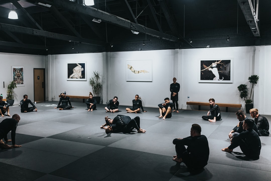 A group of athletes training in a martial arts or mobility studio, emphasizing functional movement and fluid dynamics.