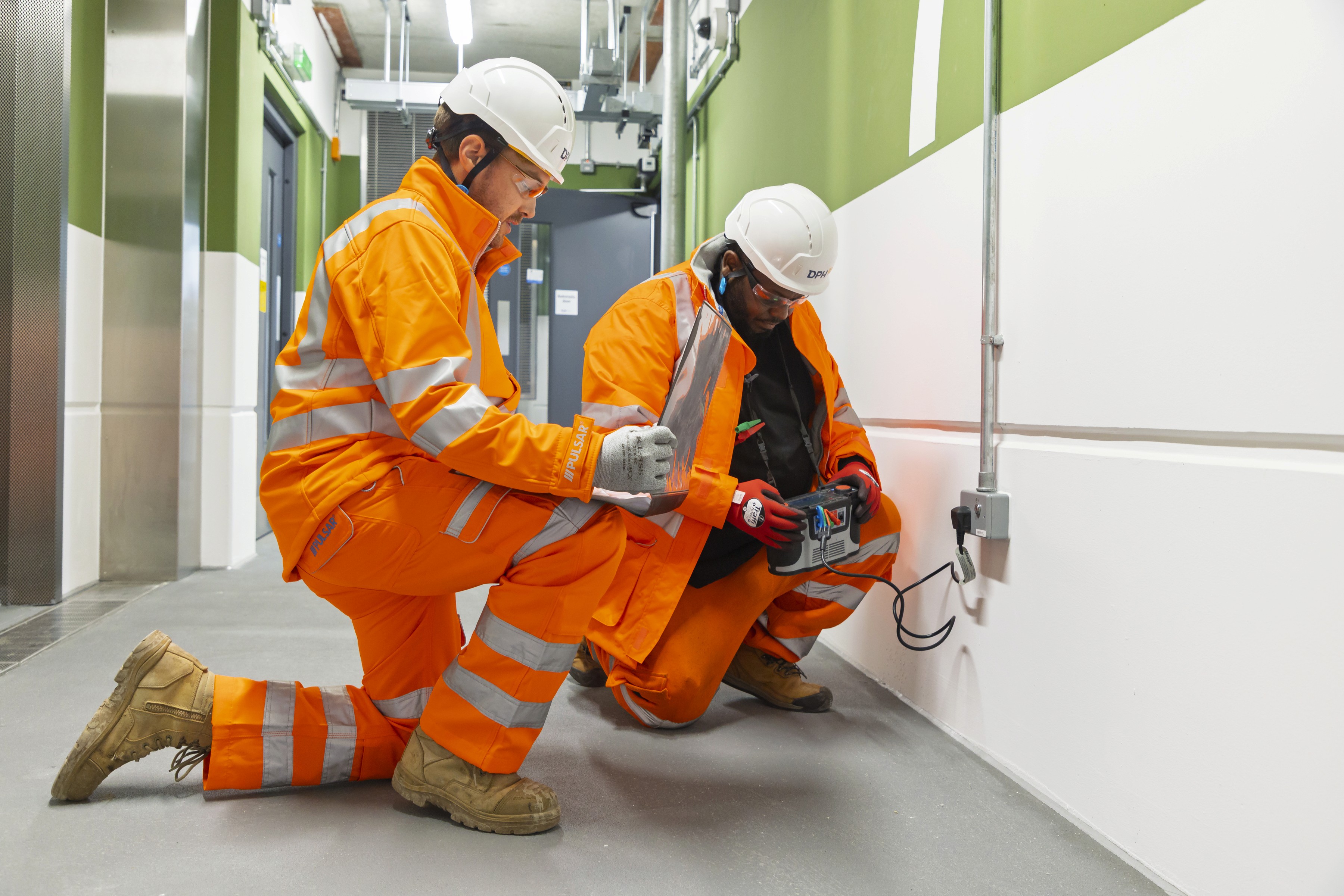 Modern glass buildings with illuminated facades and trees on a rainy day