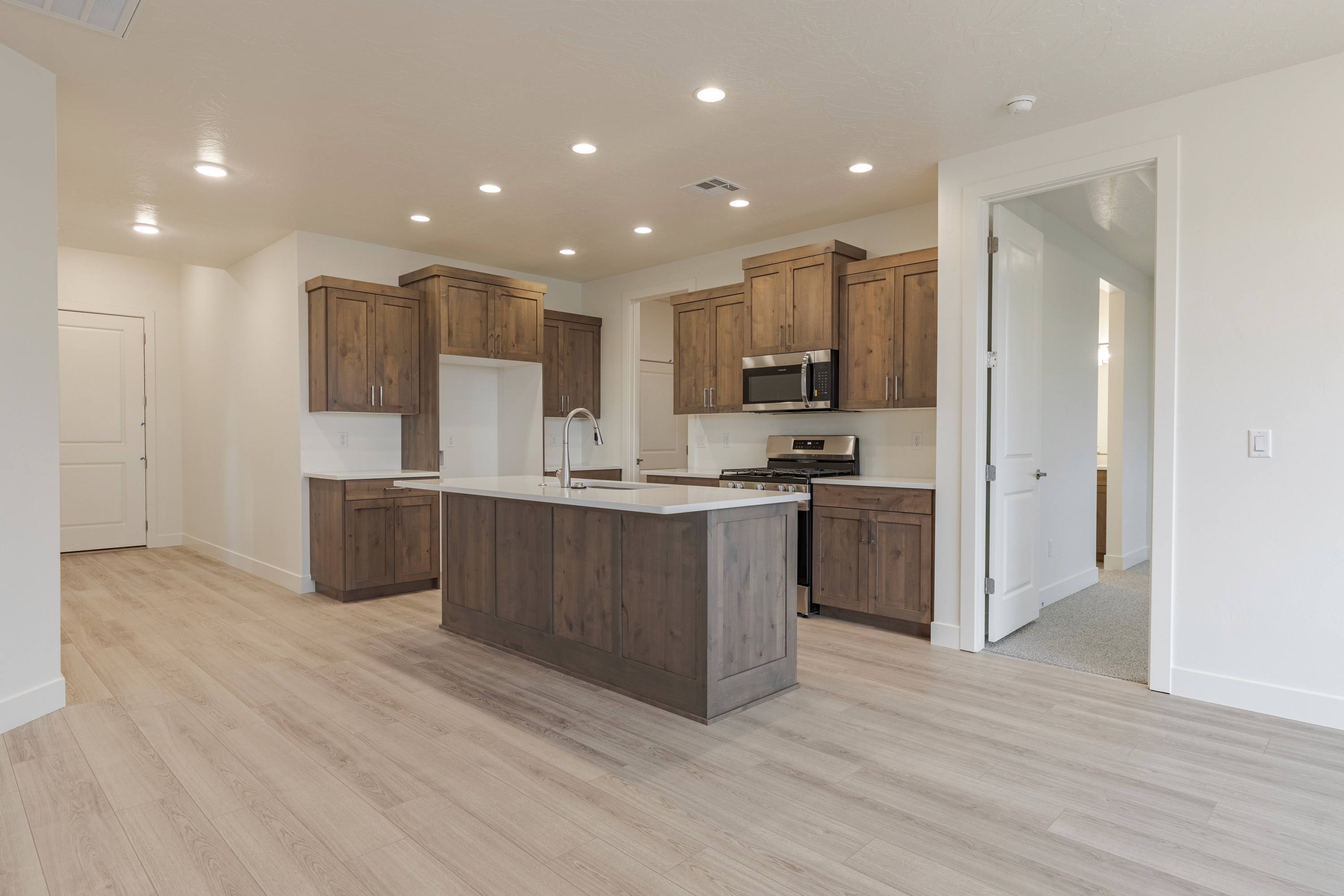 Kitchen view in the Painted Sands twin home in Hurricane, Utah highlighting light finishes and open flow to living spaces.