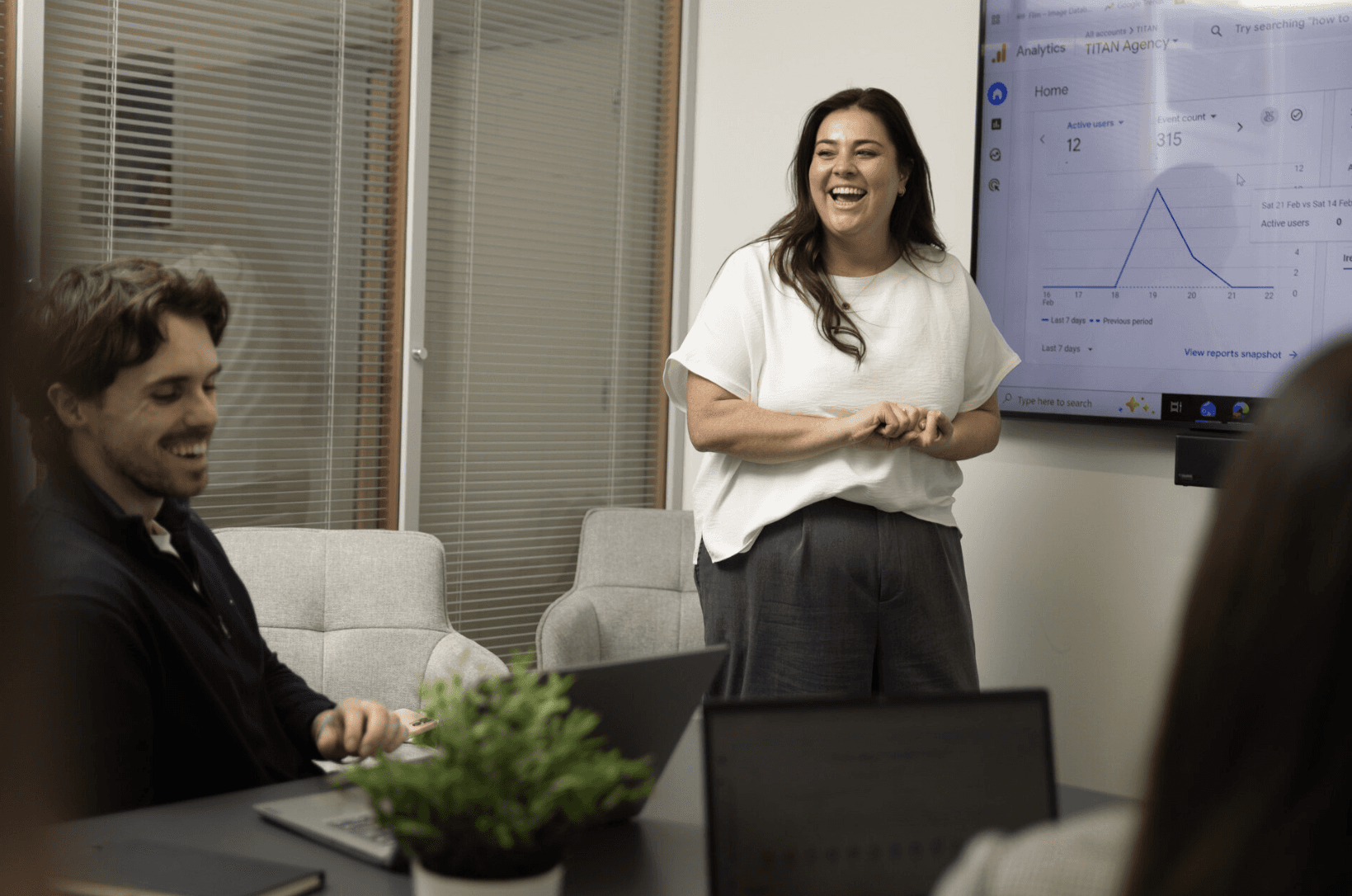 A group of four people engaged in a discussion while seated in a cozy, plant-filled setting.