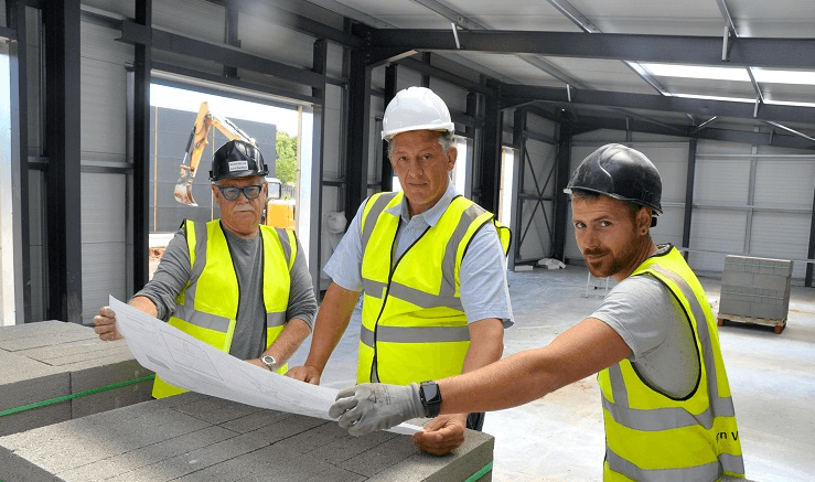 Matrix IDC team reviewing construction drawings inside a steel-framed industrial unit at Tern Valley Business Park