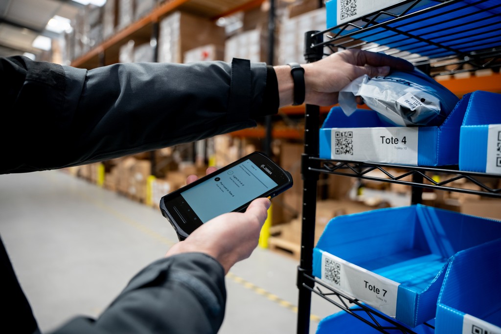 Worker scanning inventory in a large warehouse