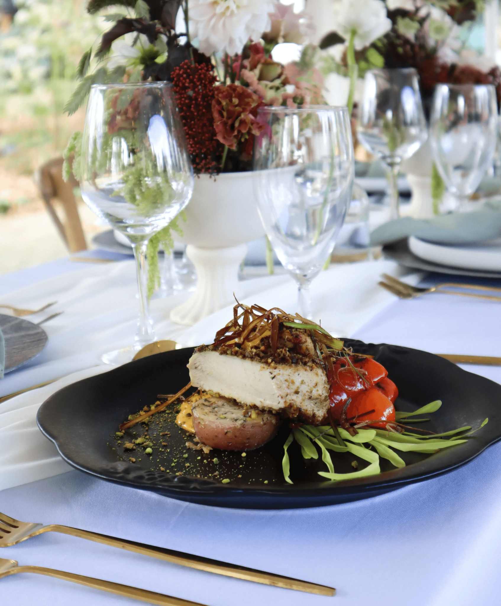 Chicken entreé plated on pristine black plate for wedding in Ottawa