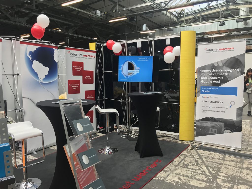 Standaufbau der internetwarriors GmbH auf eccomerce Expo Berlin 2019 mit Luftballons