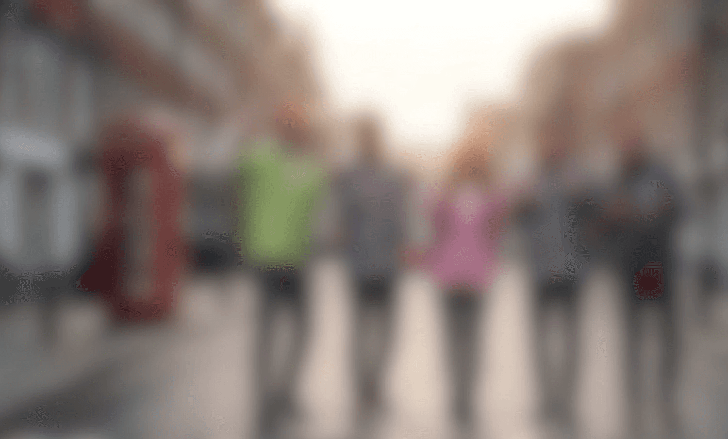 Person holding a green knitted handbag with a silver clasp, blurred green backdrop