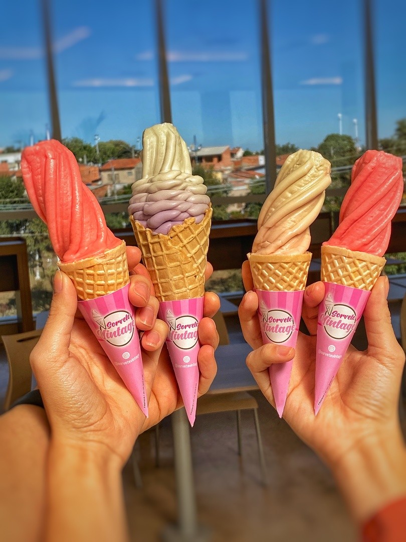 Garçom‑barista oferece espresso recém‑tirado em copo biodegradável, reforçando a hospitalidade sustentável do stand.