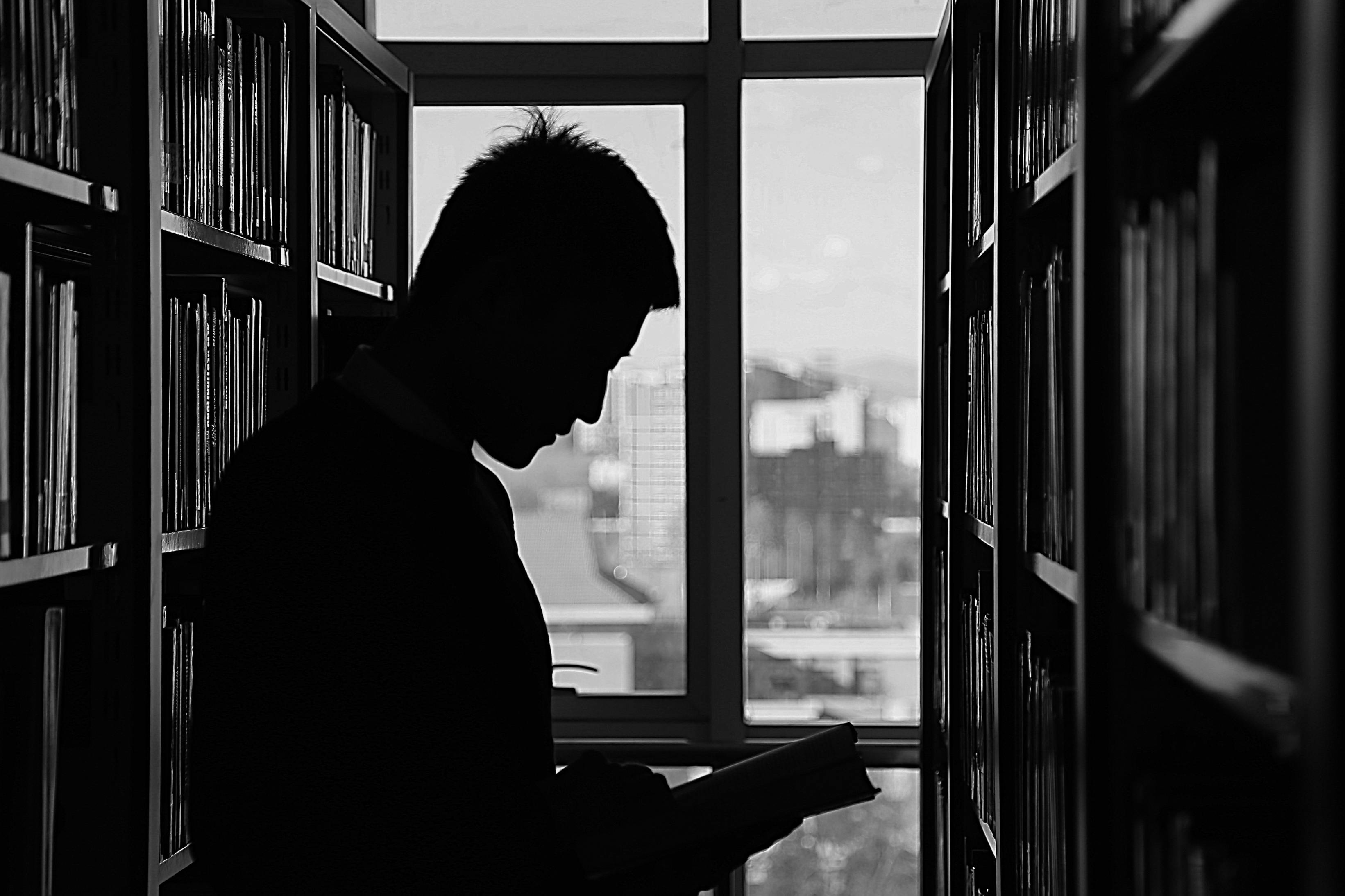 Silhouette of Man reading a book