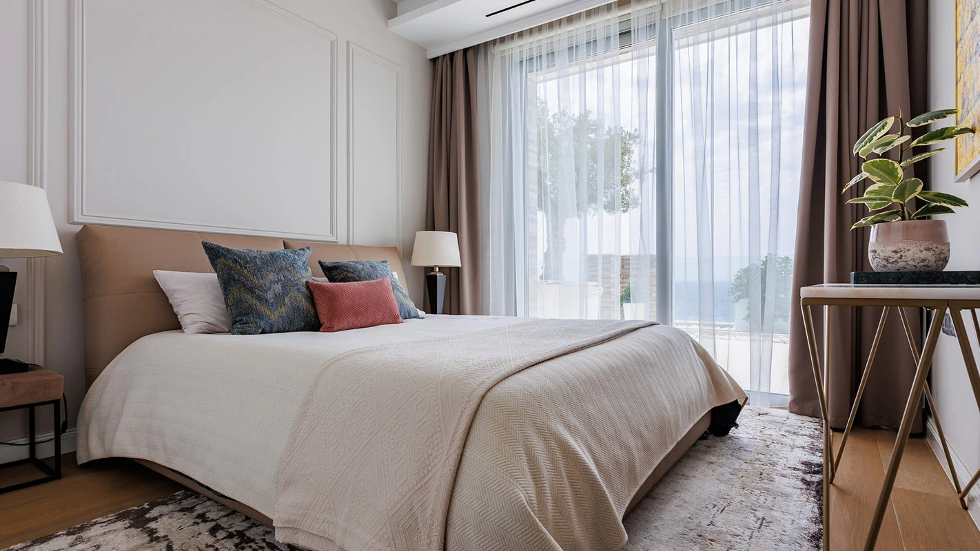 Seafront Residence Limassol bedroom retreat with soft neutral layers, textured throw pillows, and sheer curtains framing the sea view