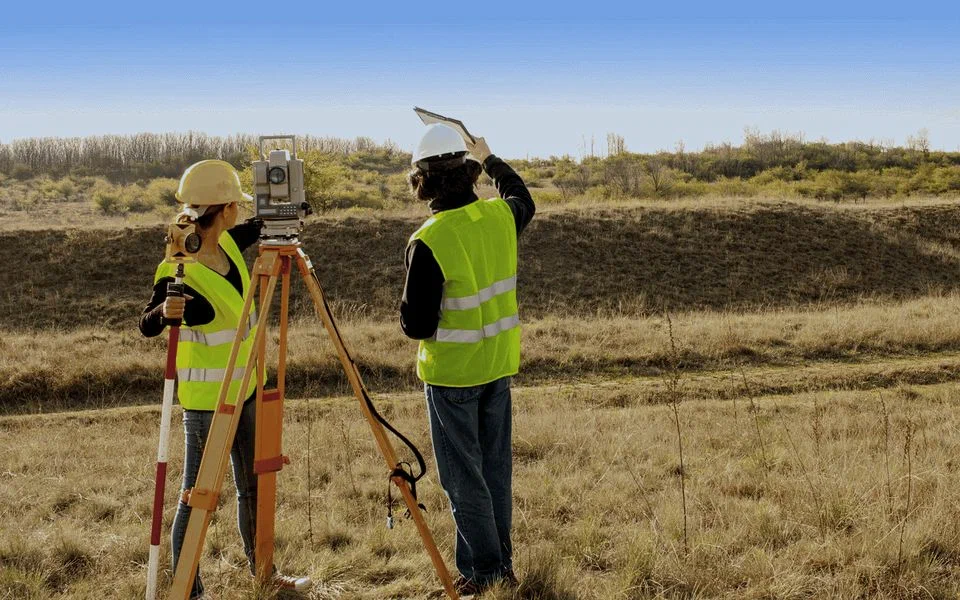 two persons surveying land